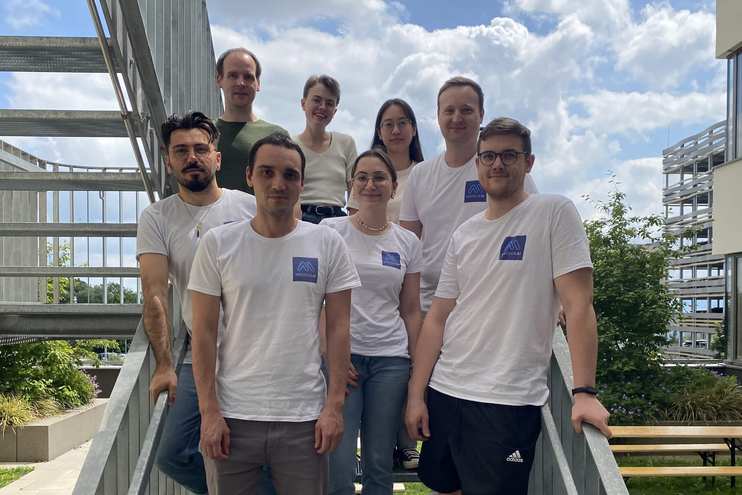Small team posing outside.