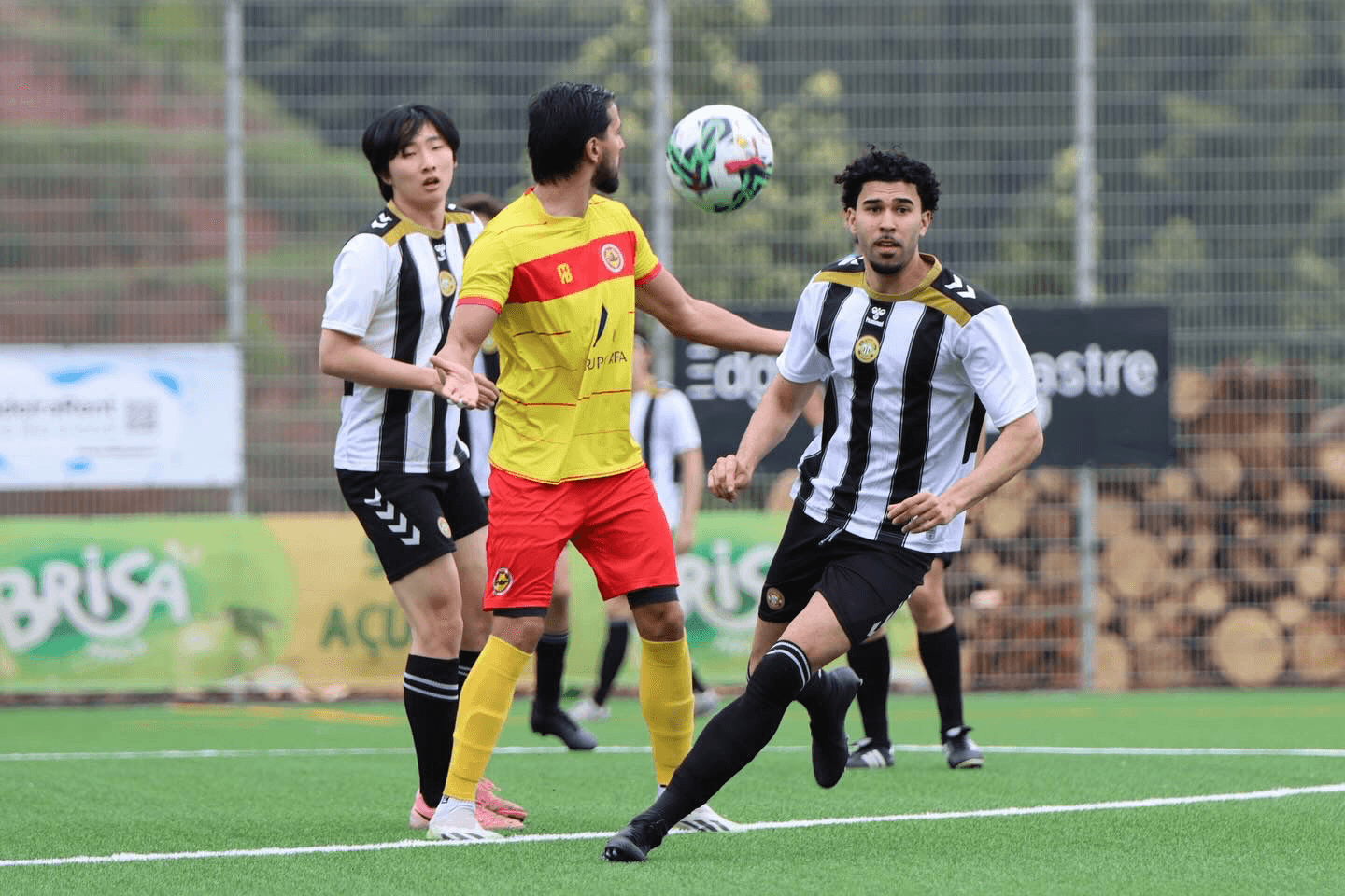 woman in black and white soccer jersey kicking soccer ball on green field during daytime