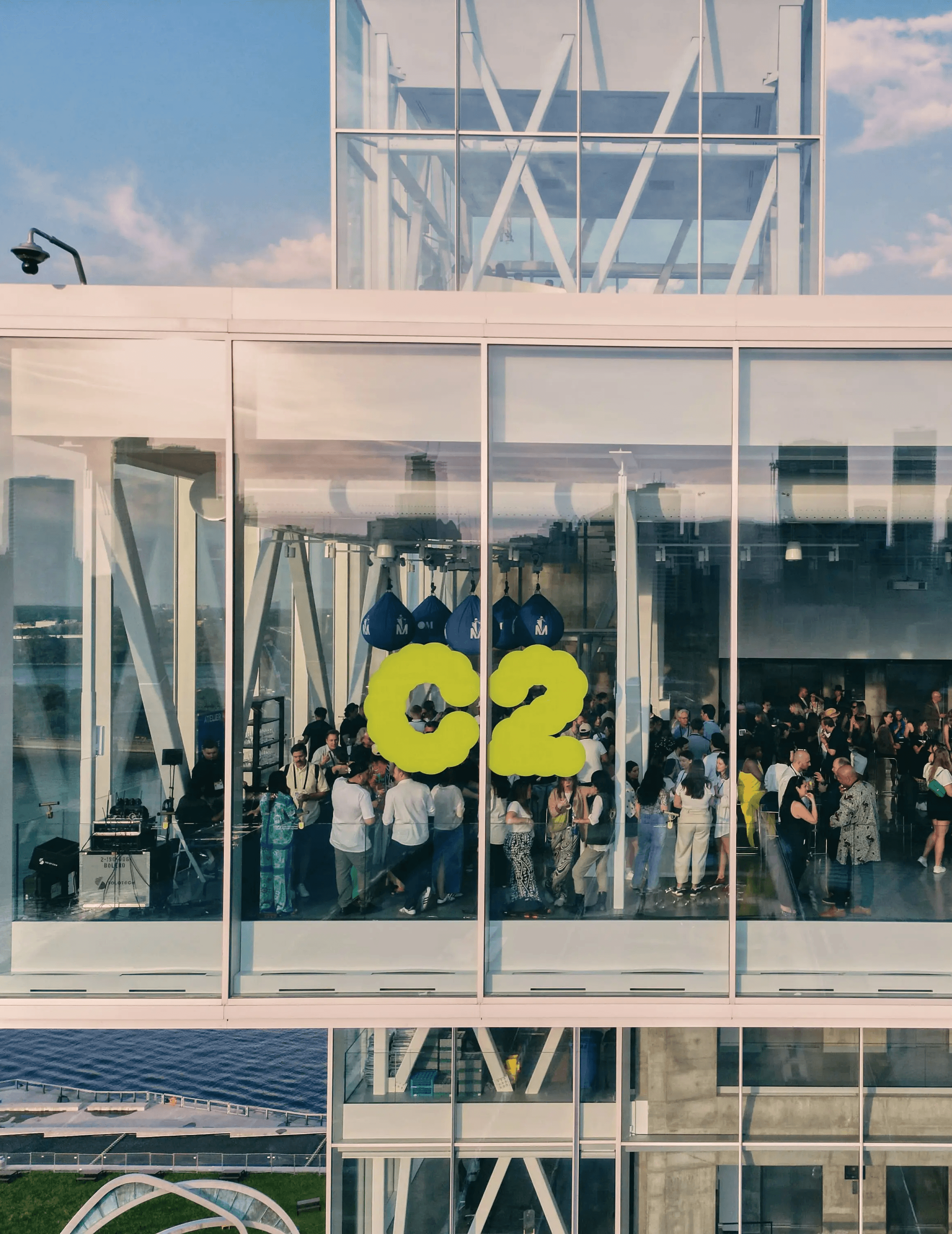 Attendees gathered behind glass windows featuring the C2 logo during a major conference moment.