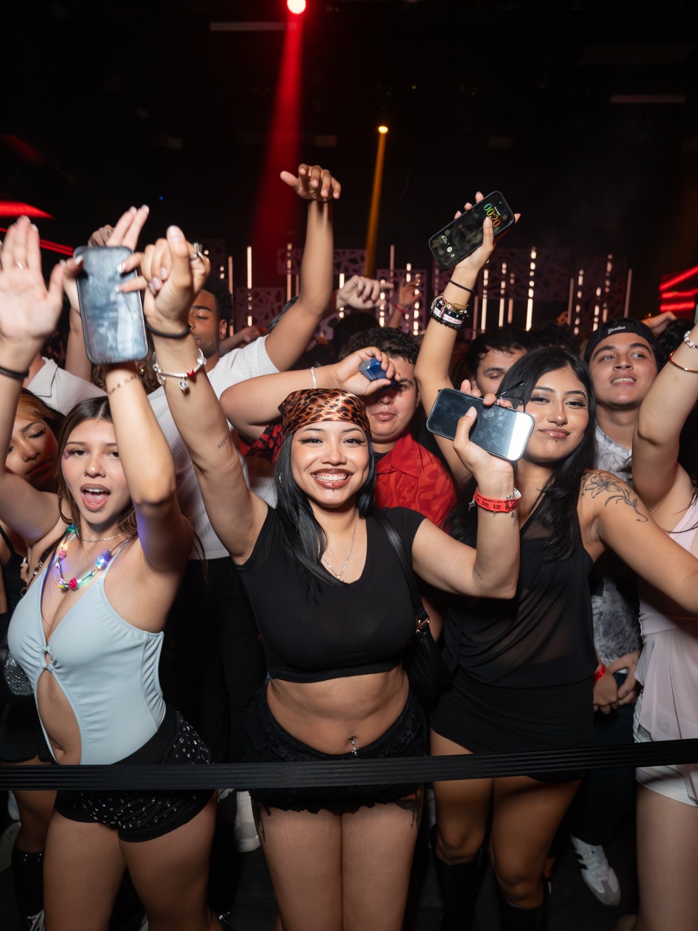 Performer with arms spread wide, captured in a dramatic pose against a light background.