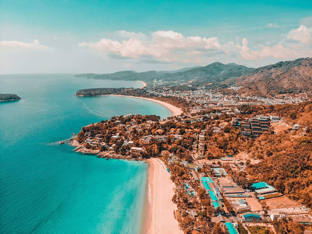 A boat traveling down a river next to a city