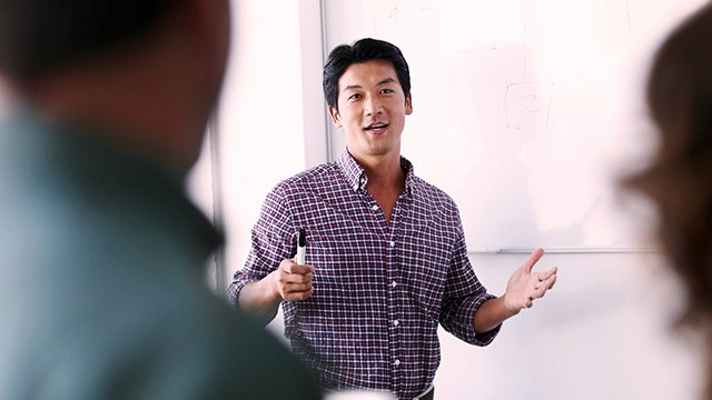 a man speaking in front of a group.