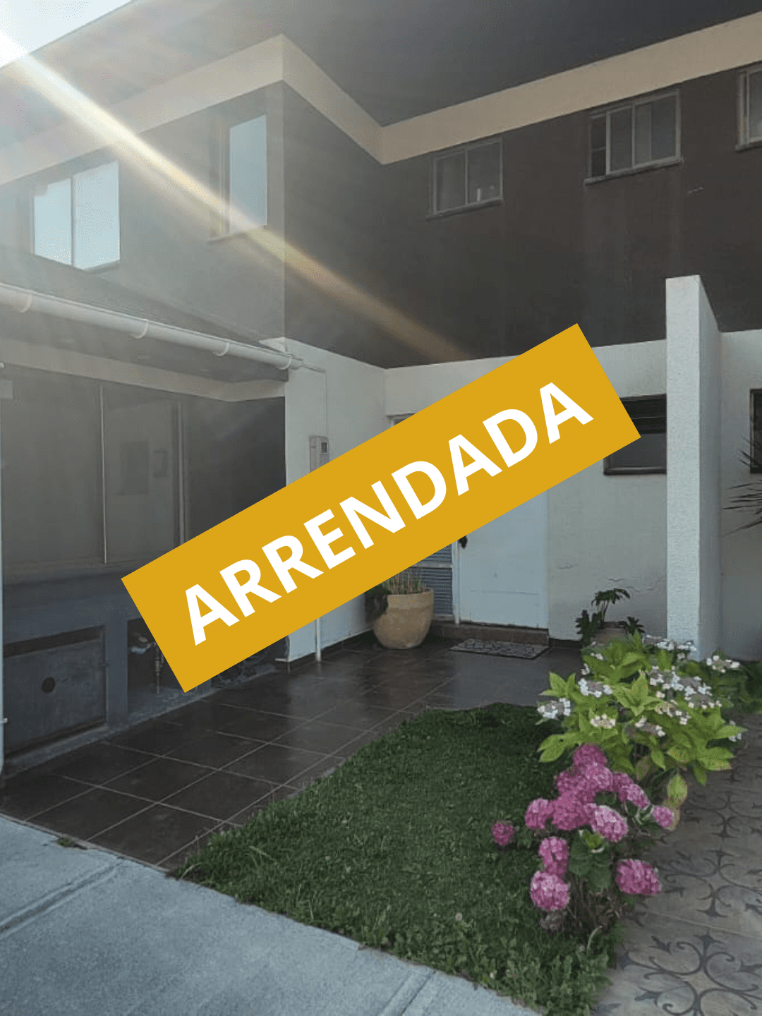 Large house with a wrap-around balcony overlooking a lit pool and deck at night.