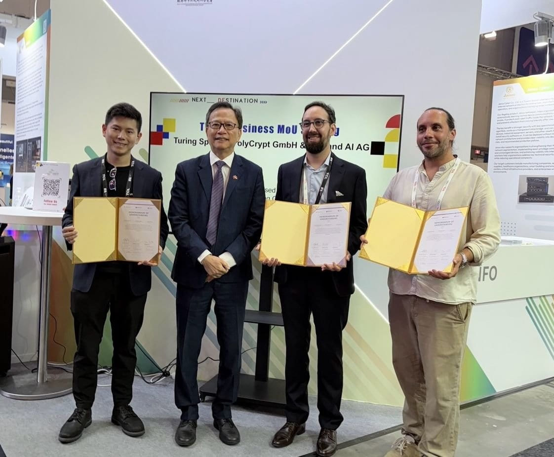 Vier Personen halten unterzeichnete Memoranden of Understanding auf der IFA Berlin. Von links: Turing Space, Dr. Klement Ruey-Sheng Gu (Taipeh-Vertretung), Yunus Philip Uyargil (neuland.ai), PolyCrypt.