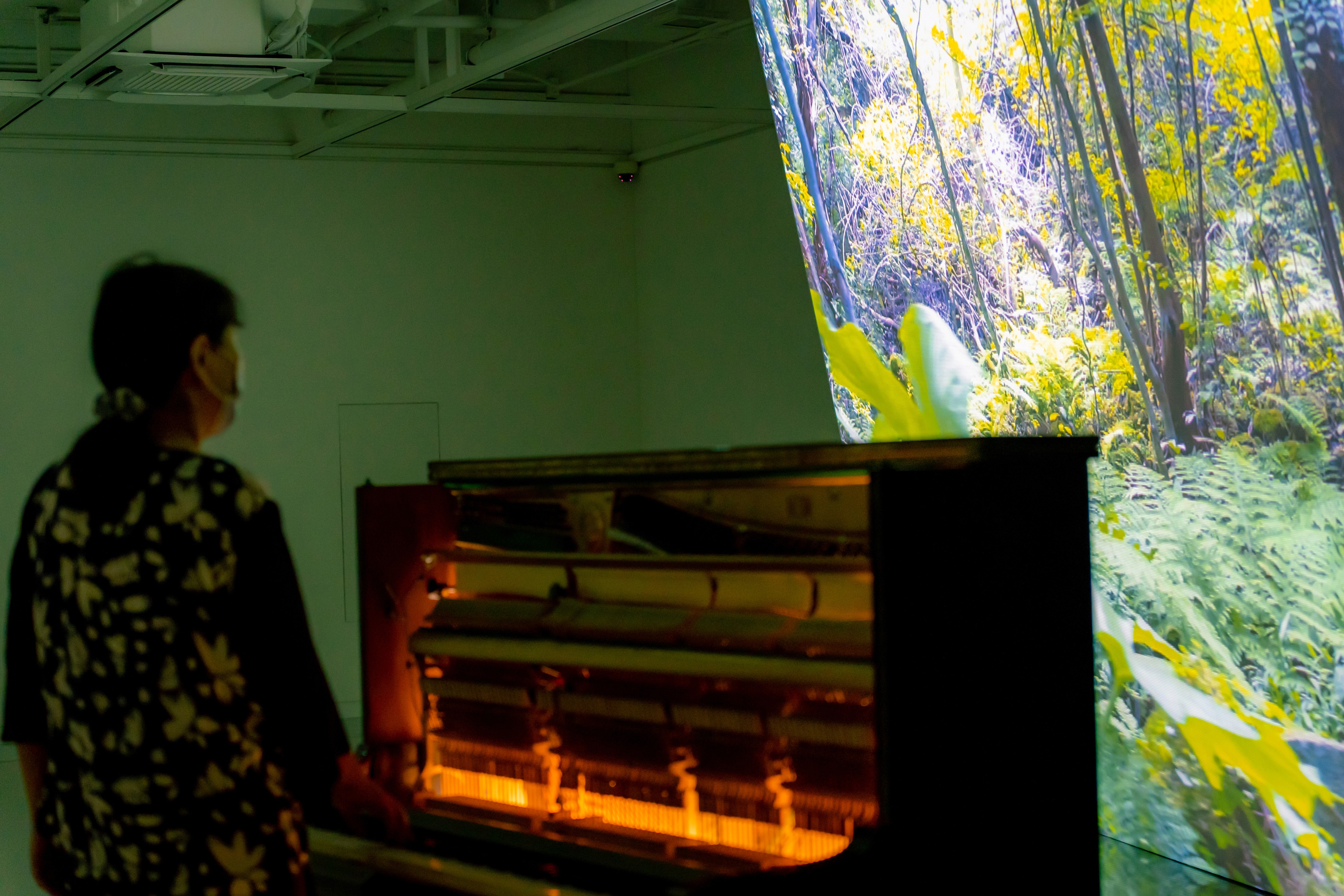 Close-up of model in orange and black outfit behind glass