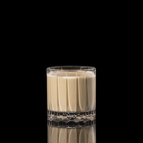 A closeup of a White Russian drink against a dark background.