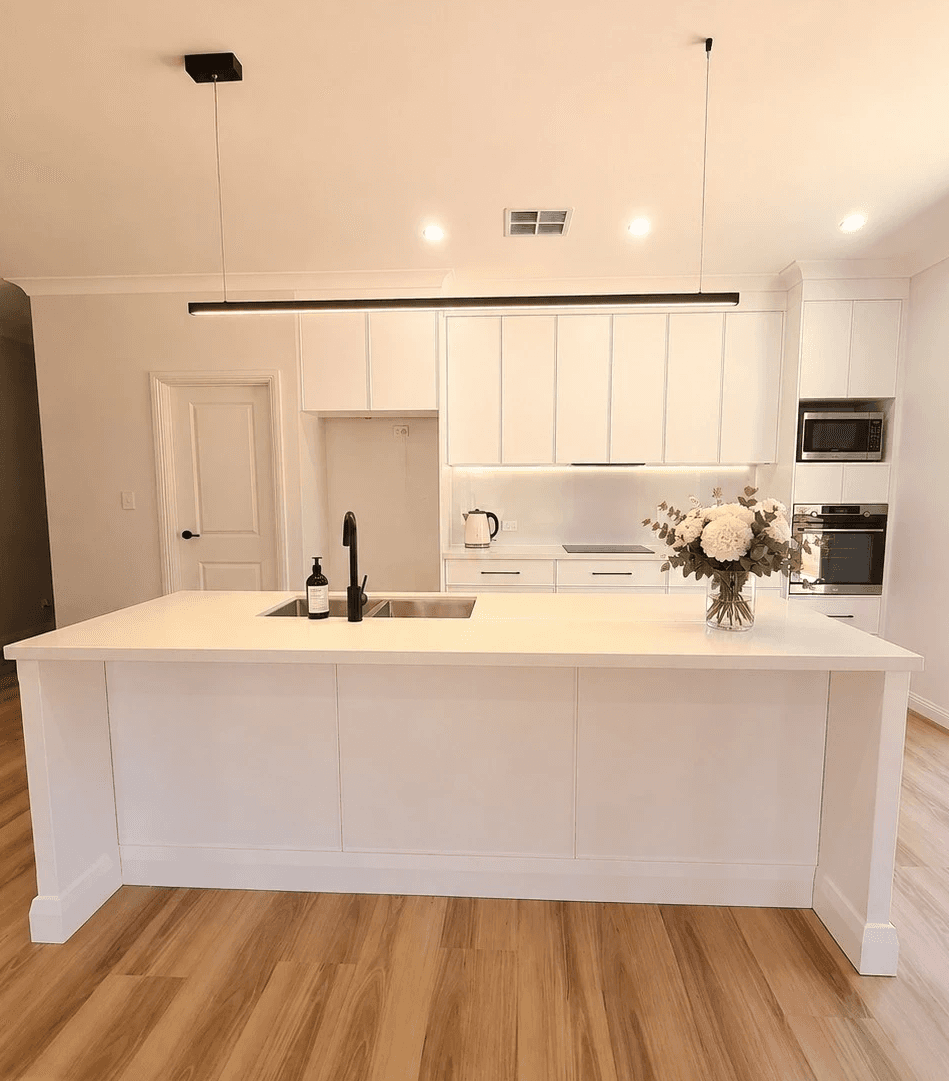 Warm modern kitchen with island, pendant lighting and custom cabinetry