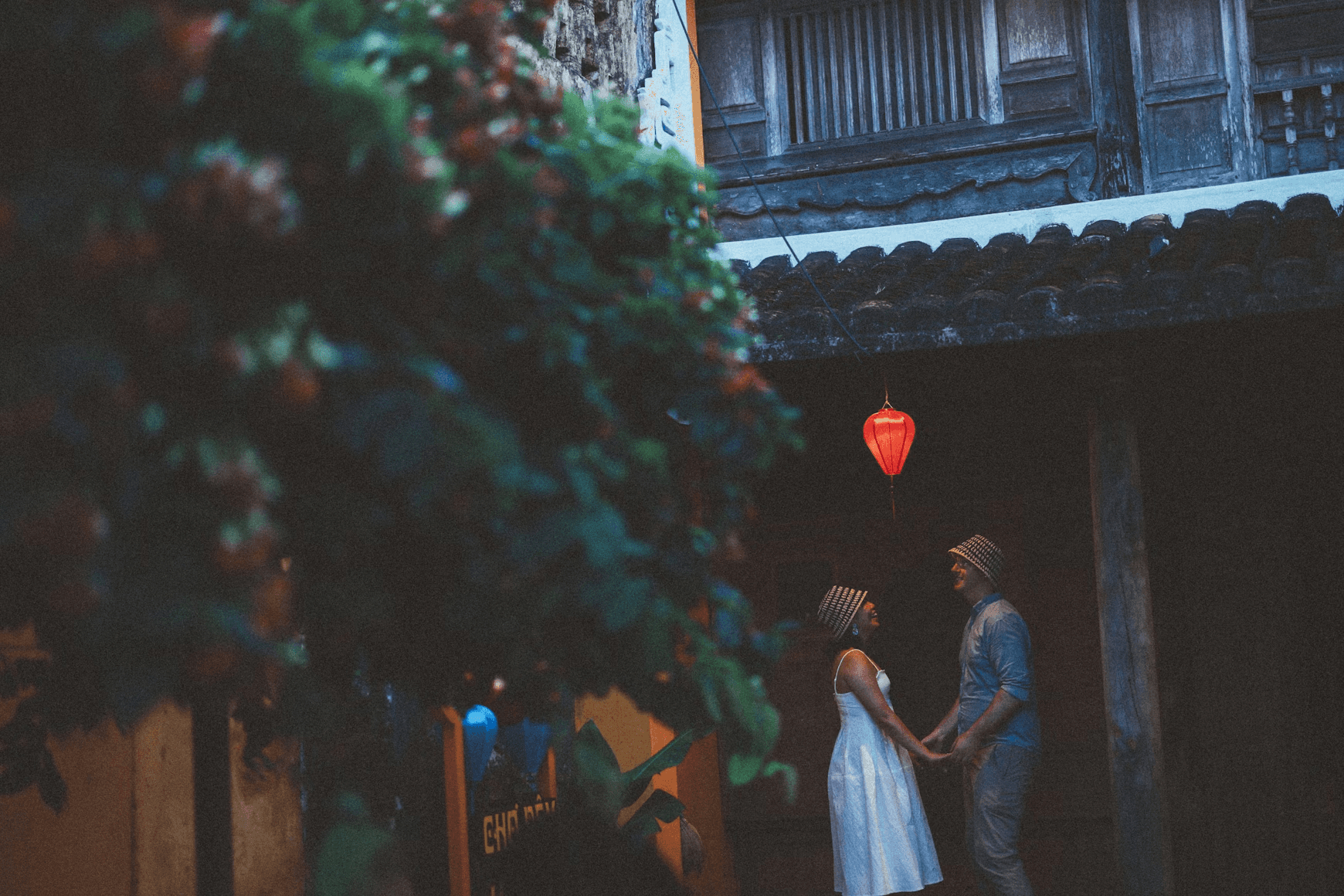 Couple holding hands under a red lantern