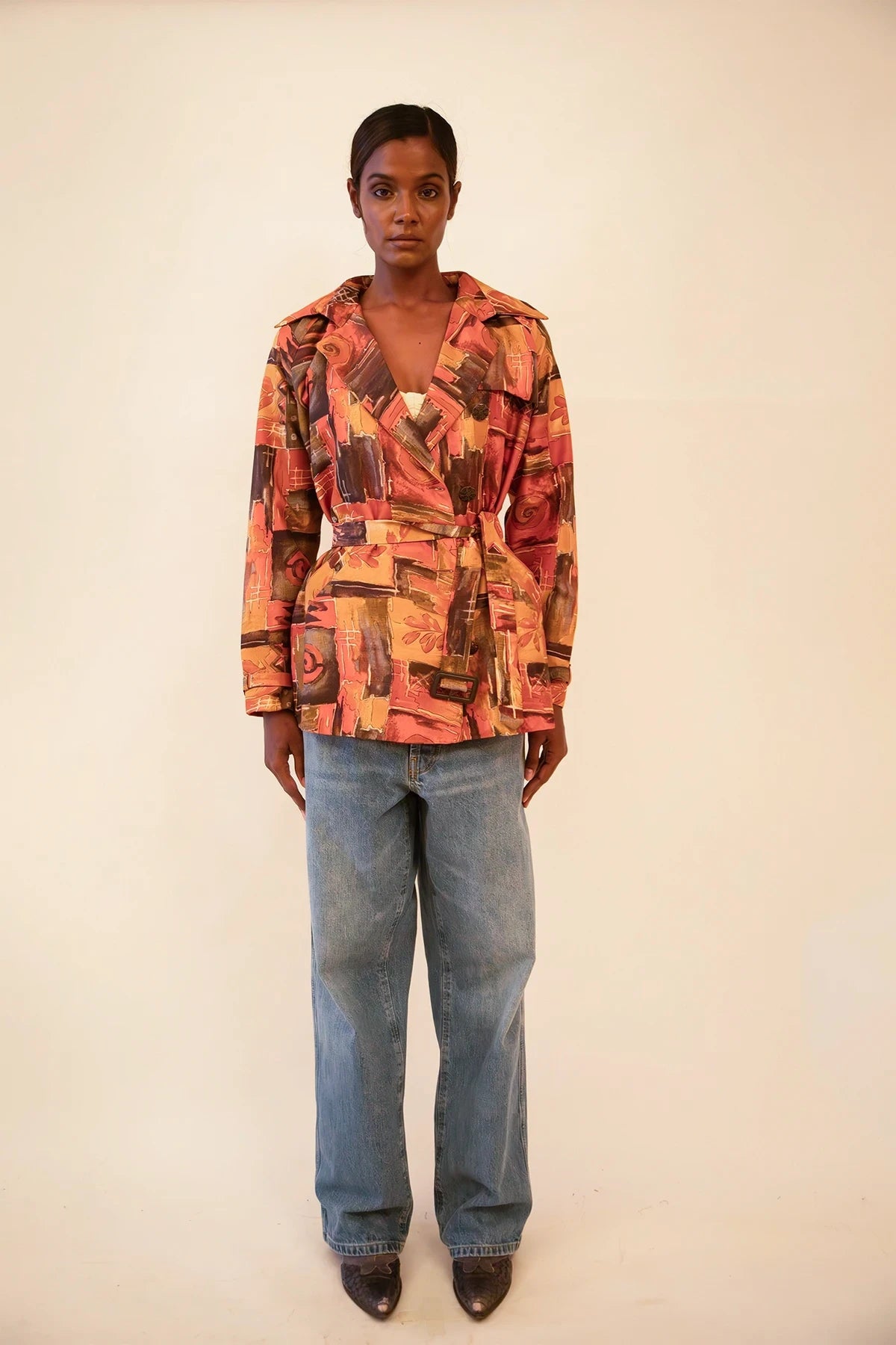Cropped trench coat crafted from upcycled abstract print silk, featuring a relaxed fit and lightweight structure.