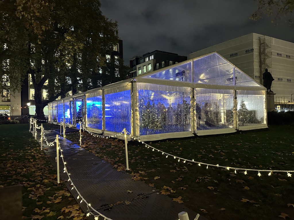 Clear event marquee illuminated blue in Hanover Square for the Oxford Street Christmas Lights Switch-On.