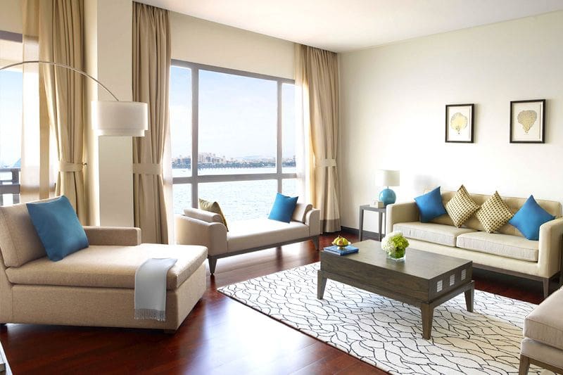 A cozy living room with a dining table and chairs, reflecting the modern decor of Oceana Residences.