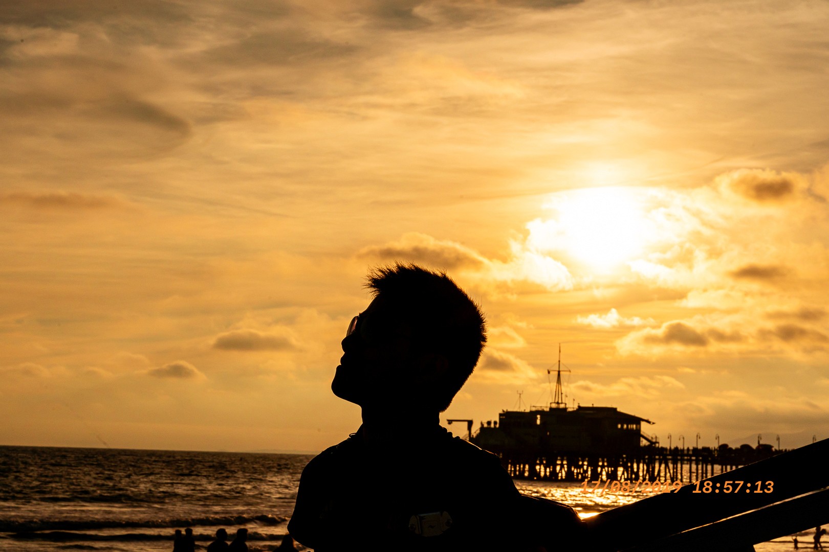 Silhouette d’un homme face à l'océan au coucher du soleil à Santa Monica Pier.