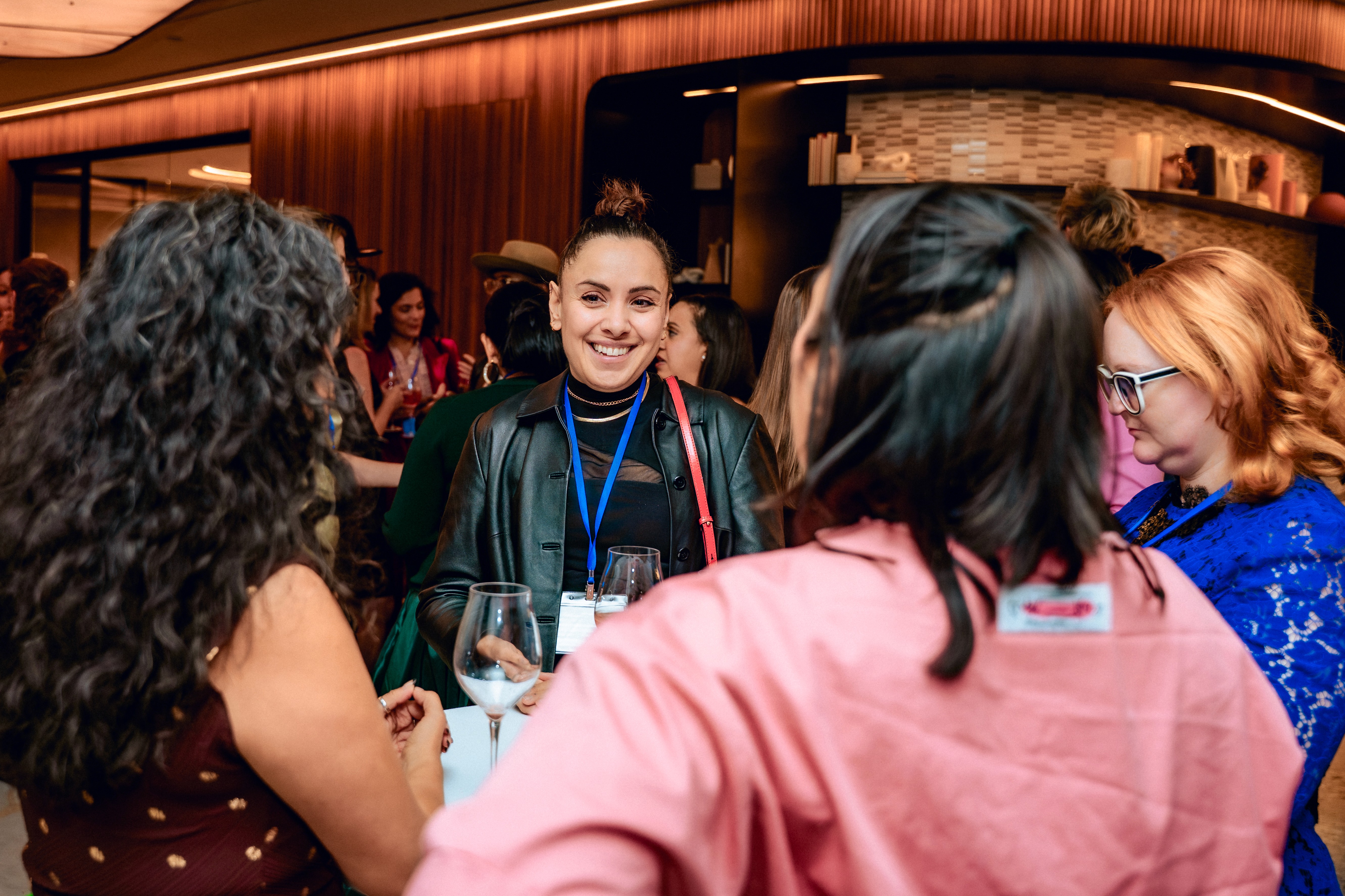 A group of 4 women standing together in conversation at the 2025 WIN Awards