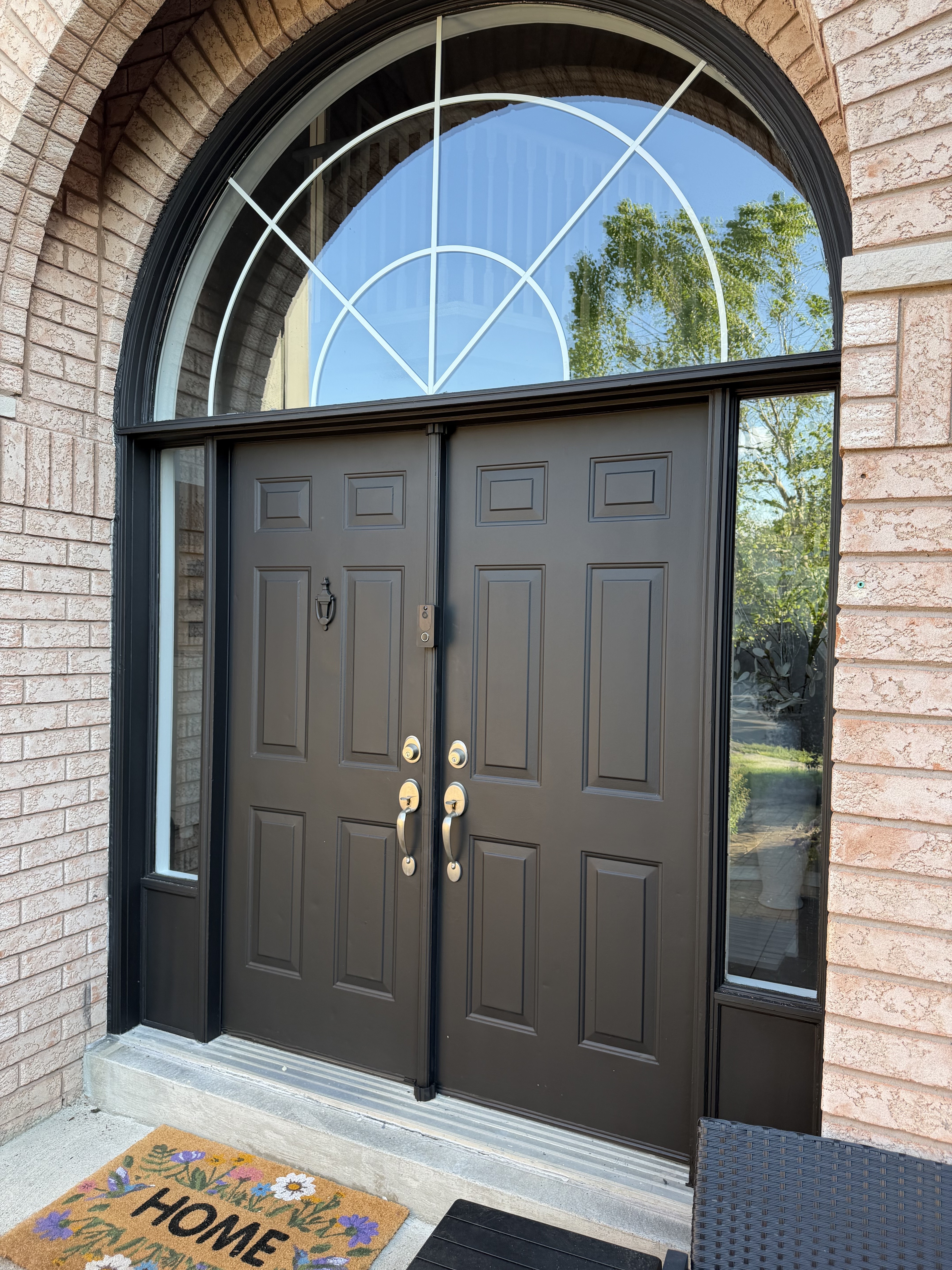 Black double entry doors with sidelights and an arched transom
