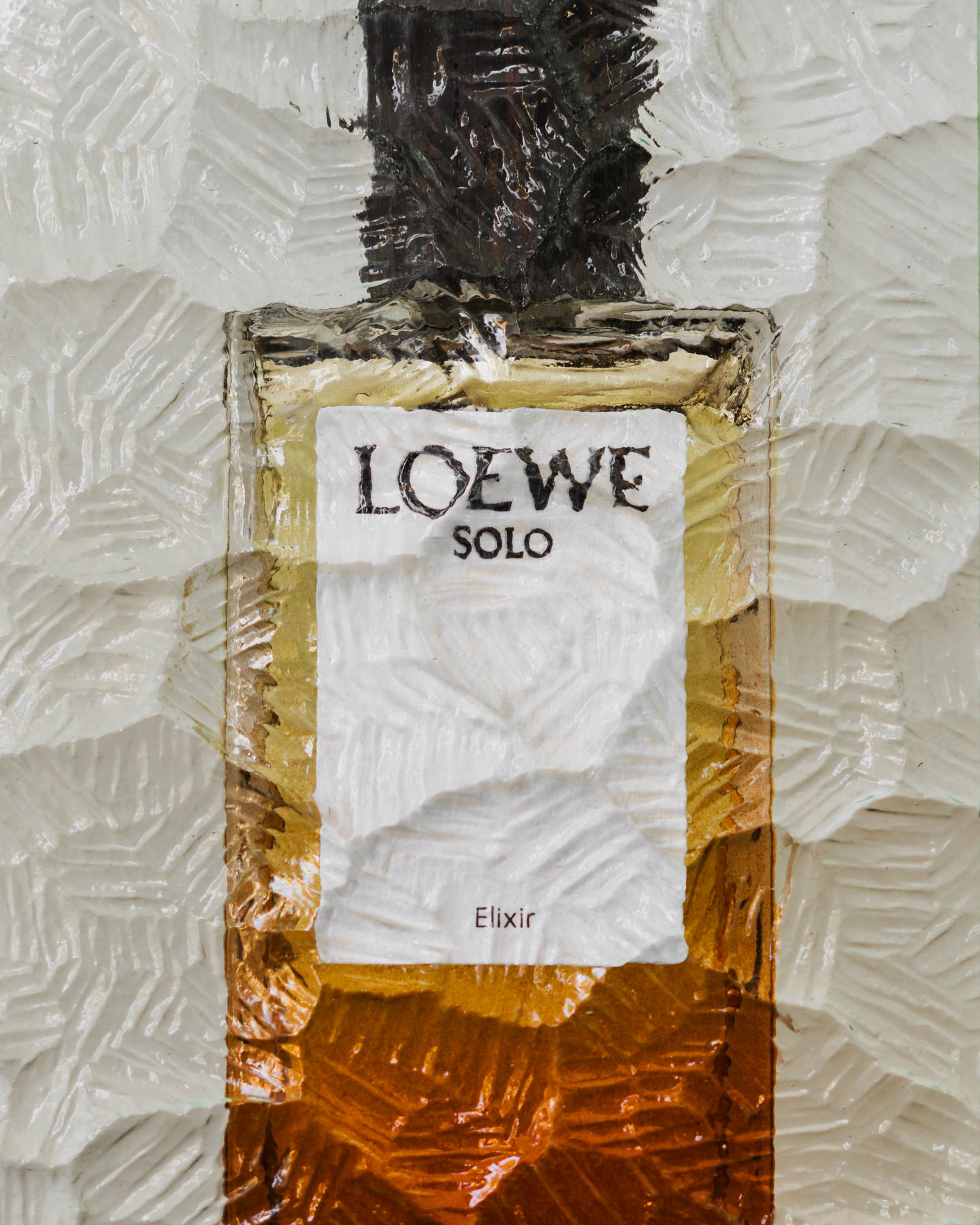LOEWE Botanical Rainbow fragrance bottle photographed against textured glass.