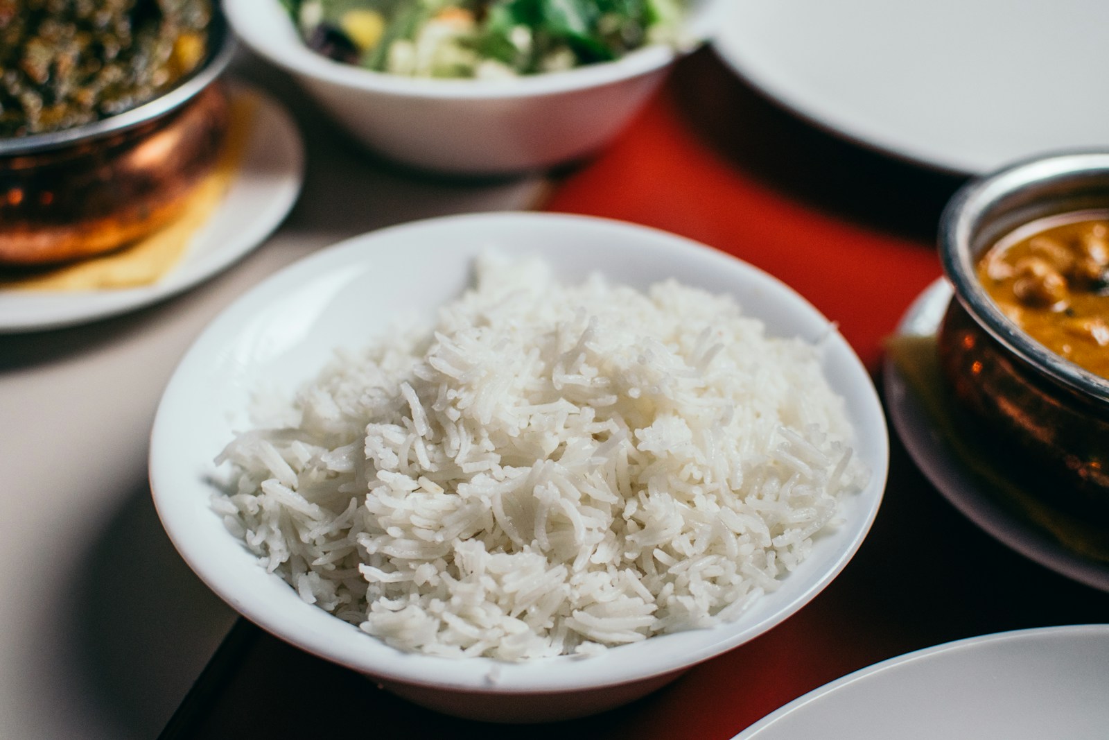 A white bowl of plain cooked white rice, an example of a gentle, low-fiber food to eat while the gut heals during recovery.