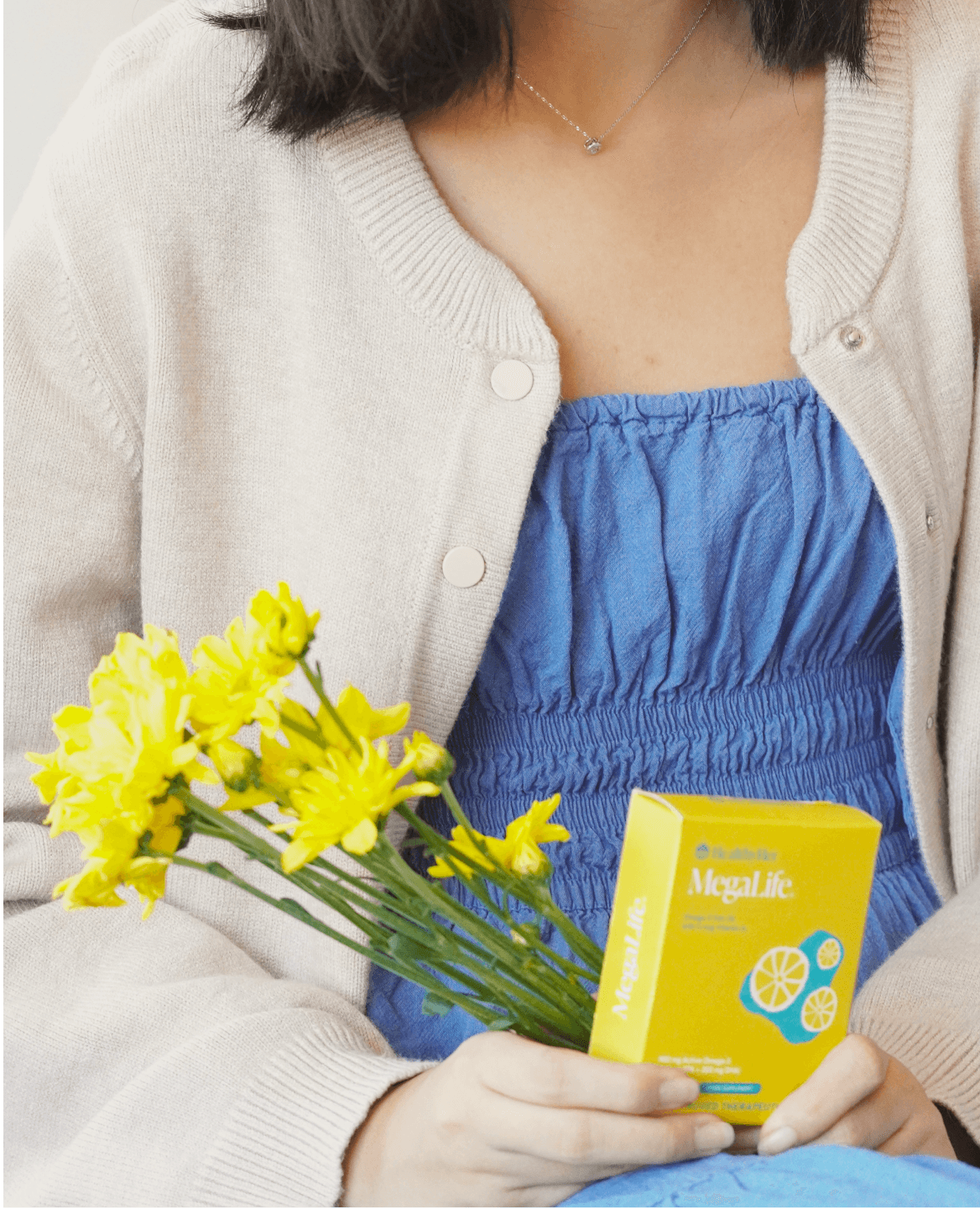 Woman is holding a box of MegaLife from HealthyHer