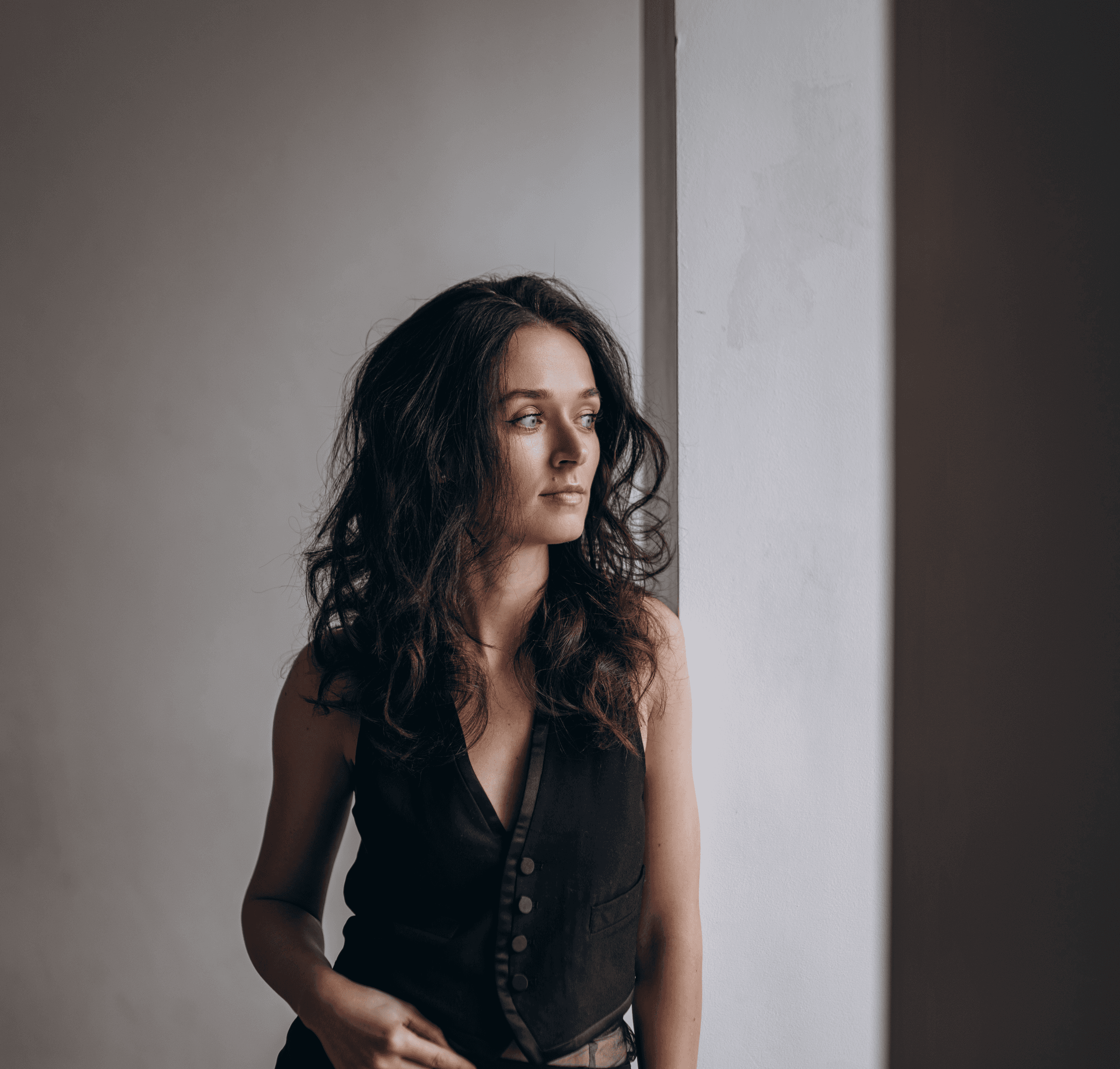 Person looking through a blurred glass surface, soft natural light.