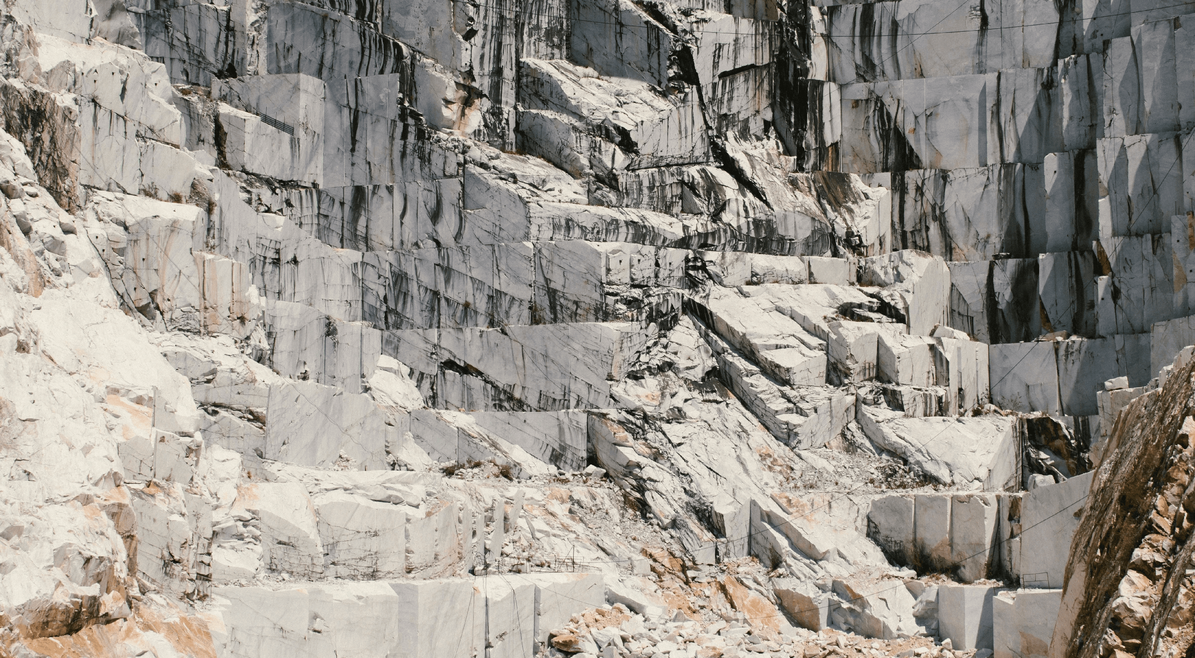 Natural marble quarry with large white marble blocks and dramatic veining, illustrating the origin and raw beauty of premium natural stone.