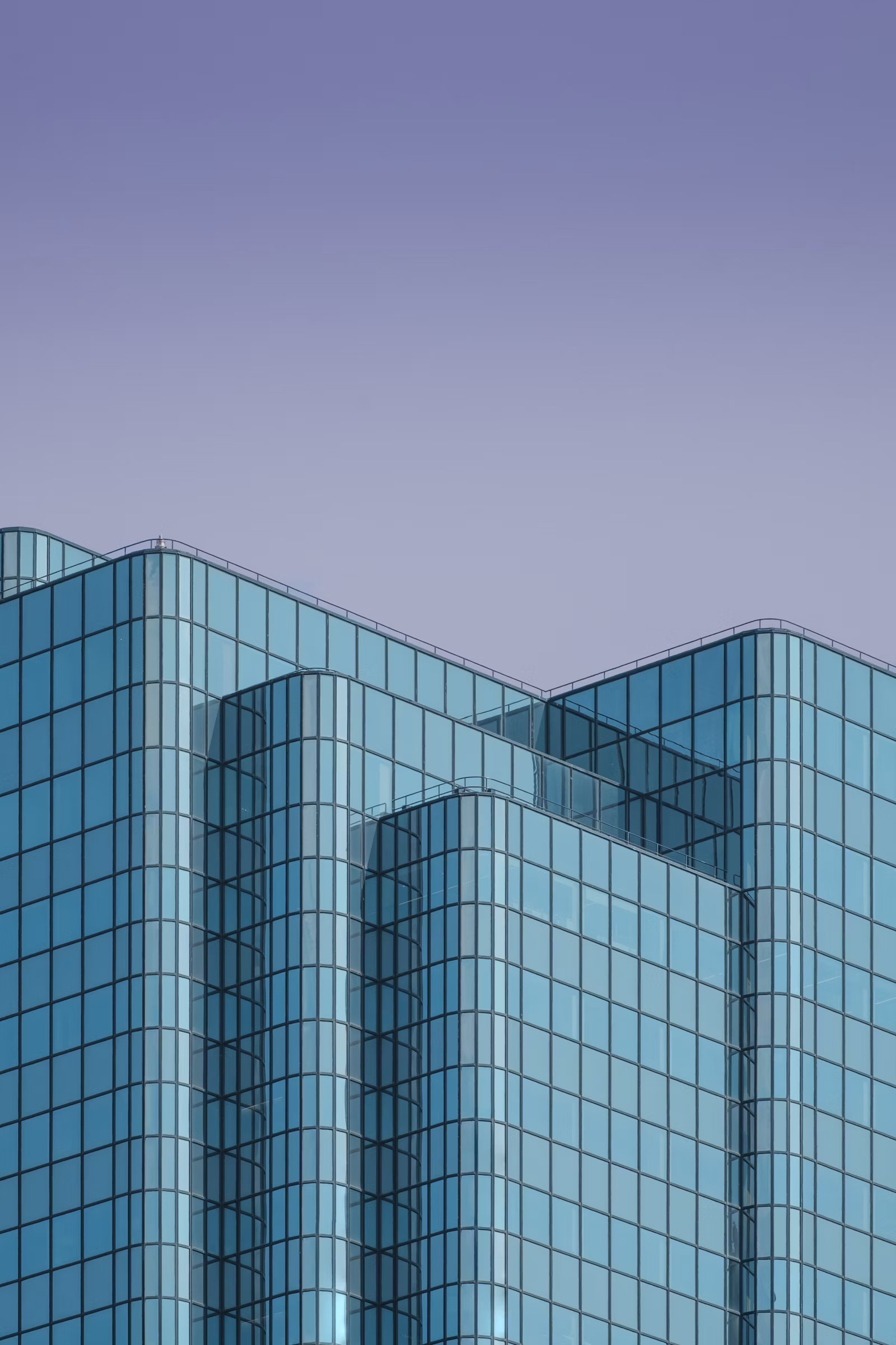 an abstract photo of a curved building with a blue sky in the background