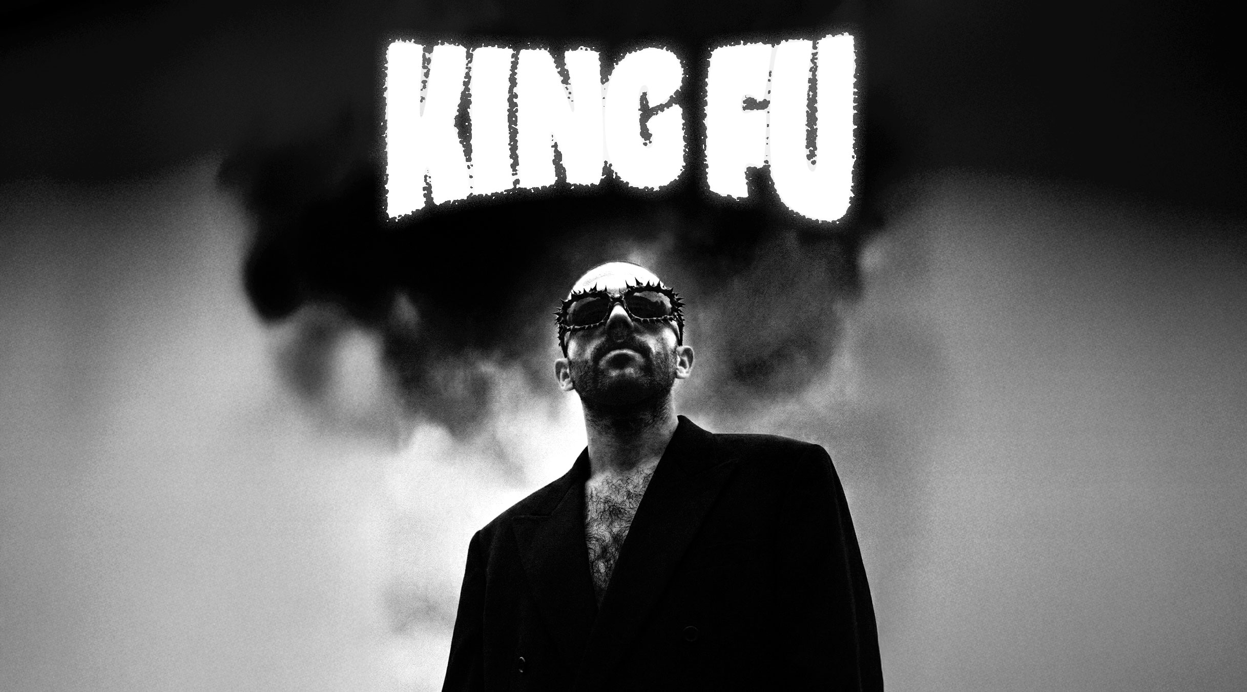 An indoor exhibition space with various artist booths at the Herofest convention in Bern. The booth in the centre of the image is the one of Loveboy and His Imaginary Friends. It features framed artworks, posters, and a small seating area with vintage televisions and inflatable palm trees. Another booth in the background, labeled 'Midnight Spells,' displays gothic-themed merchandise. The space has an industrial ceiling with exposed metal beams and bright overhead lighting, creating a creative and eclectic atmosphere.