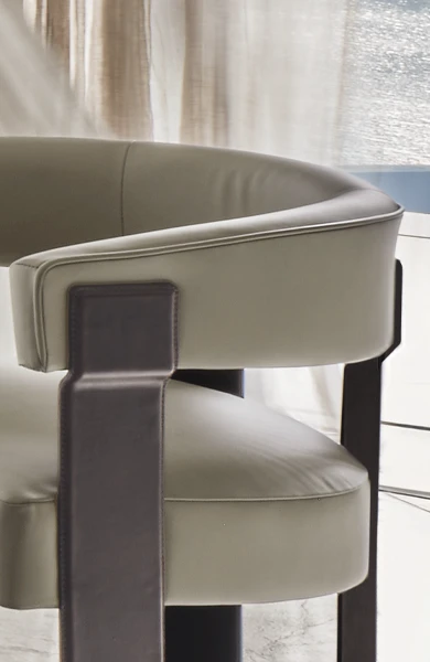 Sedia di lusso con gambe in metallo rivestite in pelle di sella in una sala da pranzo moderna in un ambiente urbano.