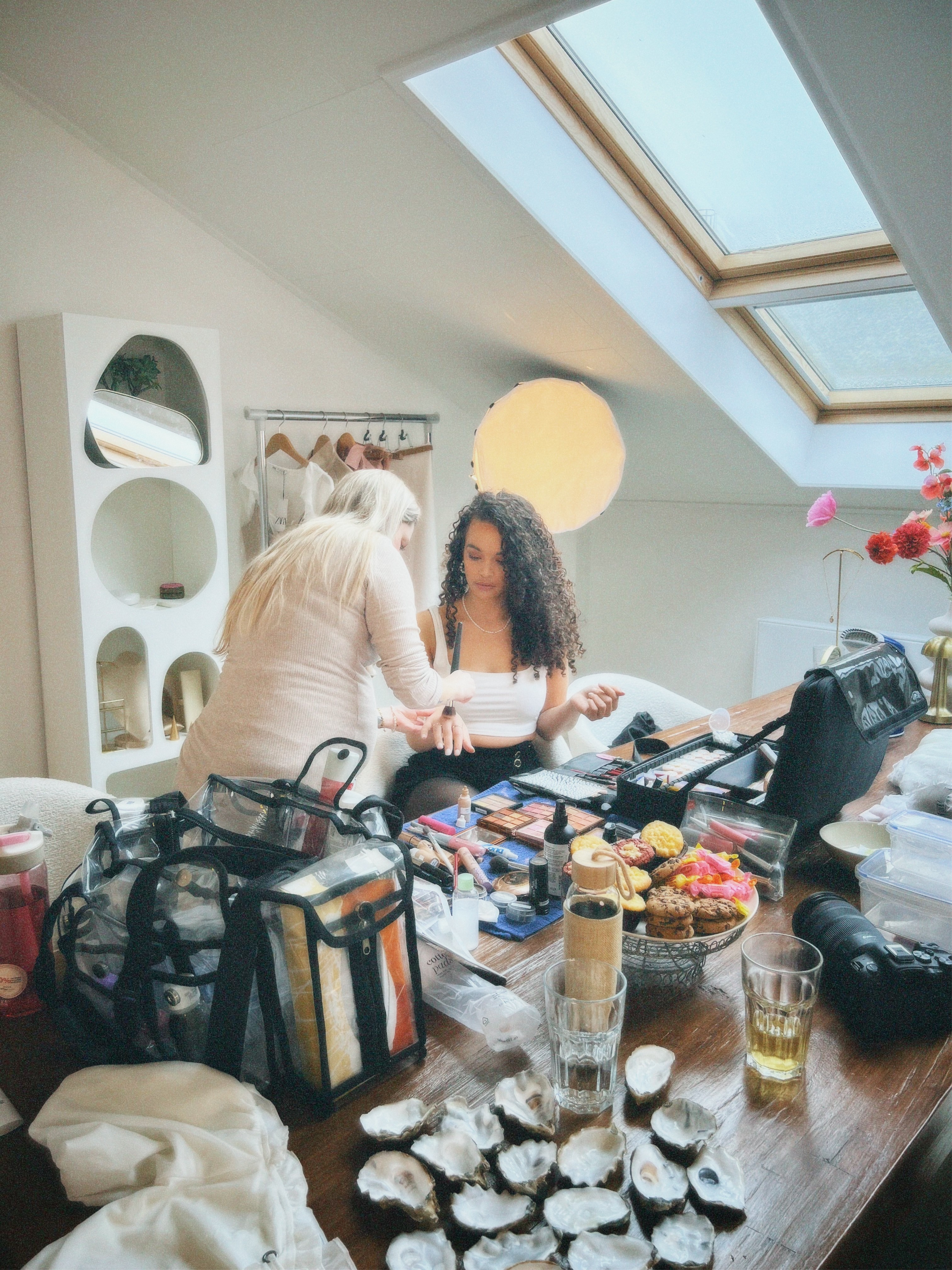 Black and white photo of two people looking at a computer screen with papers on wall
