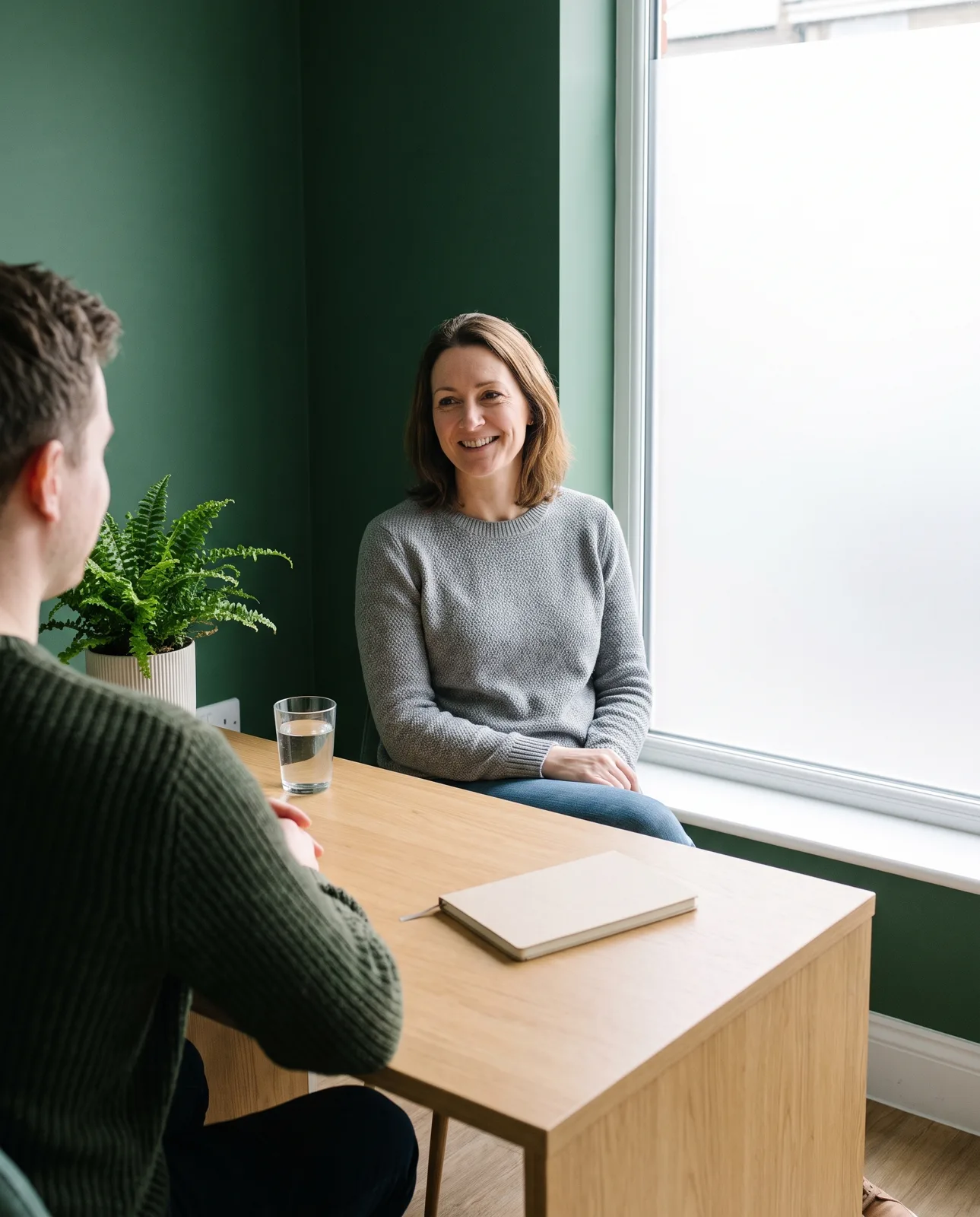 A patient talking with a pharmacist in a calm private consultation room