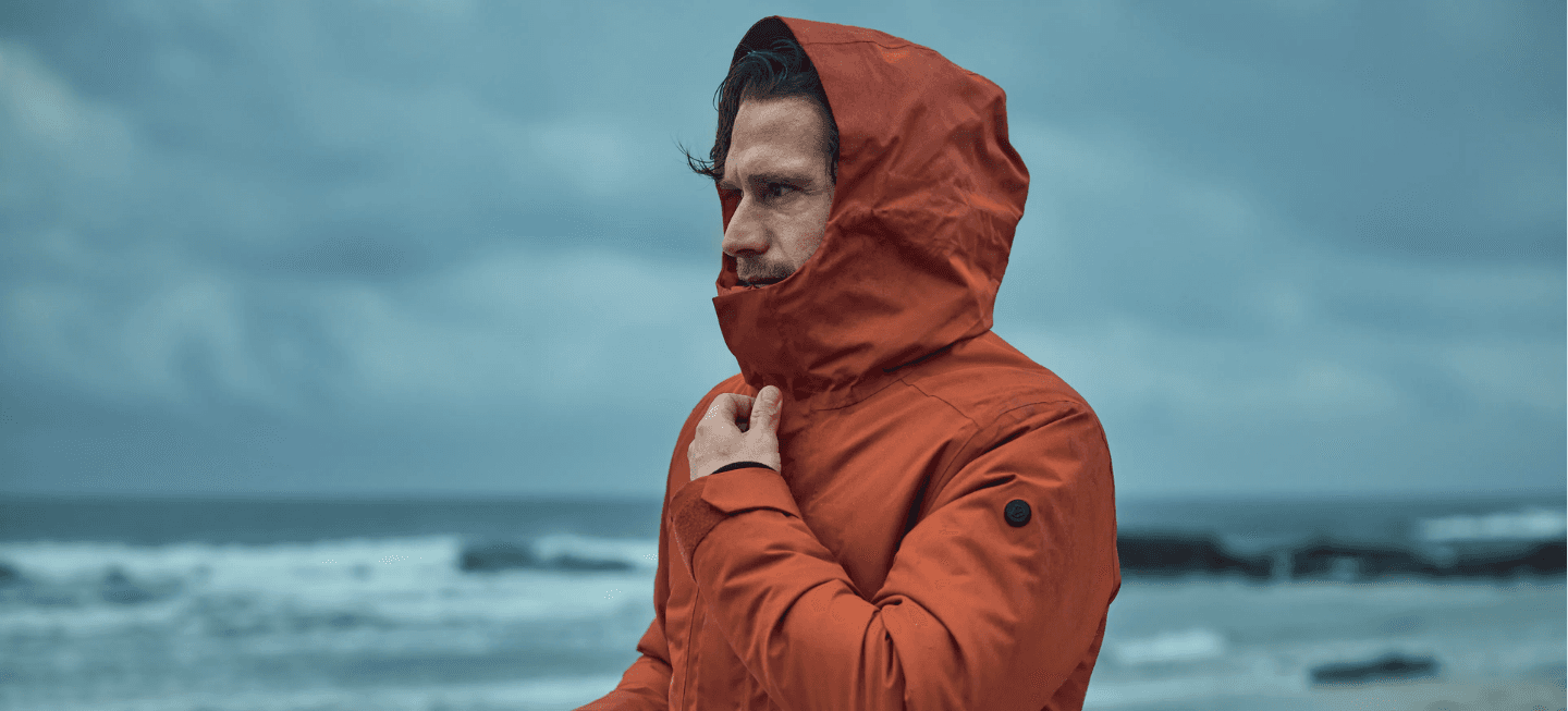 Image of a person wearing a Didriksons jacket at the beach