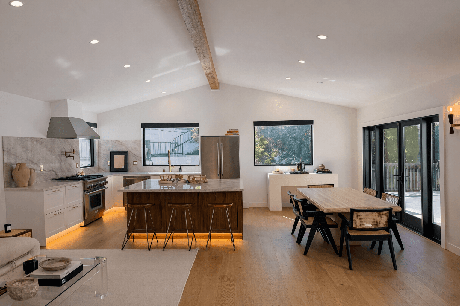 Modern living room with black leather sofas and tree-patterned rug