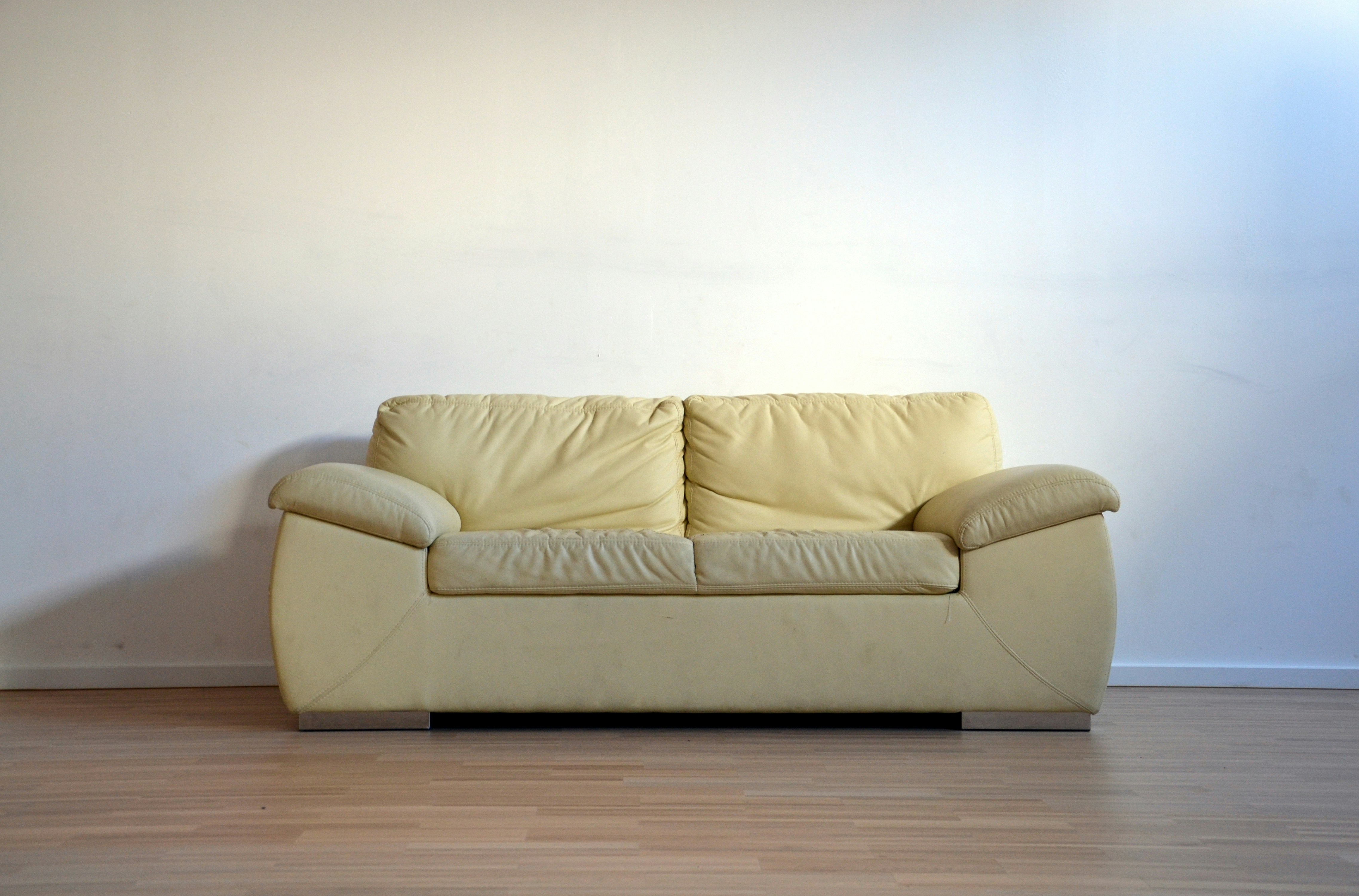 Yellow soft sofa aginst the wihte wall