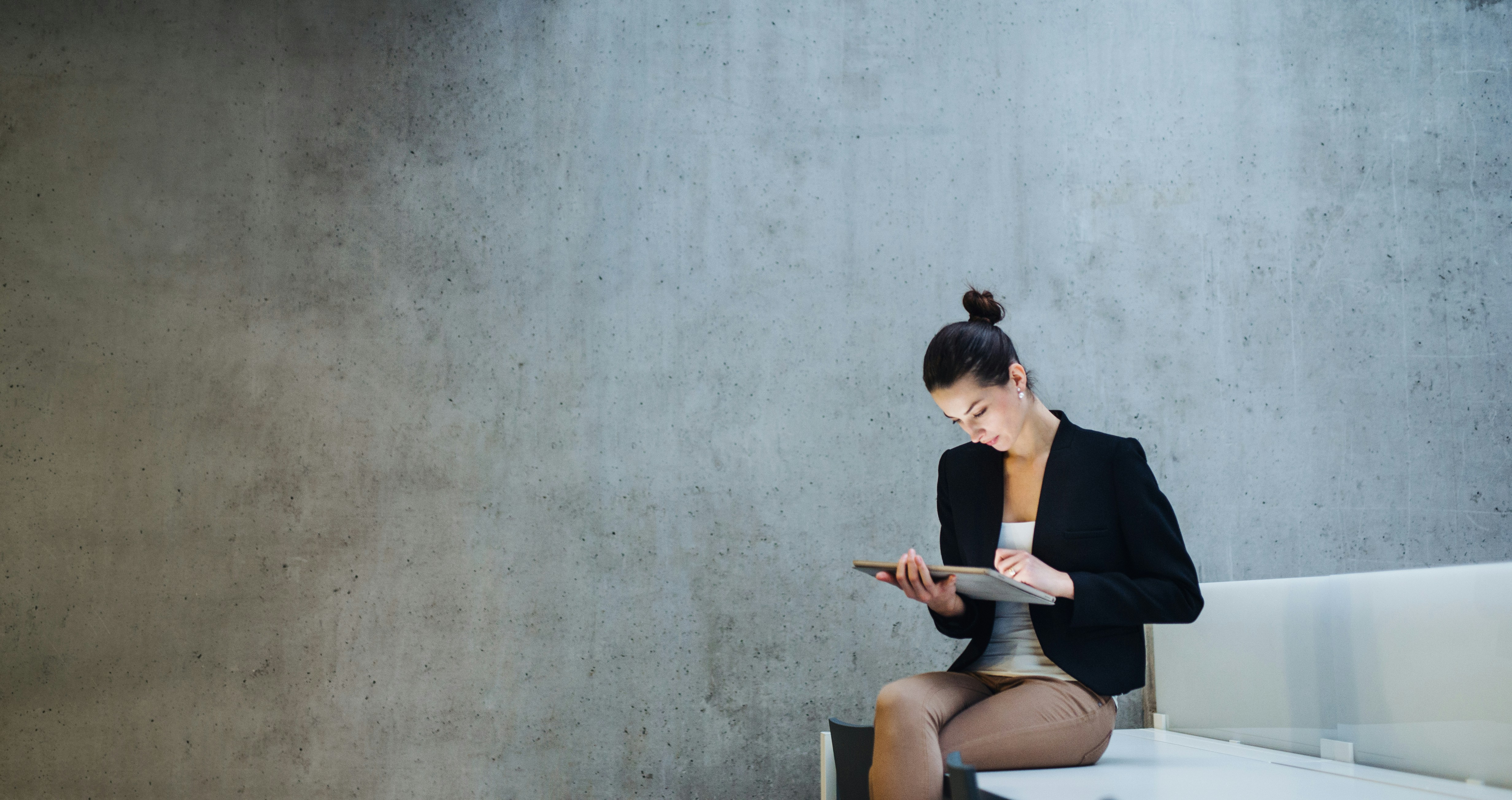 Scientist in a lab coat using a pipette in a dimly lit laboratory with advanced equipment in the background.