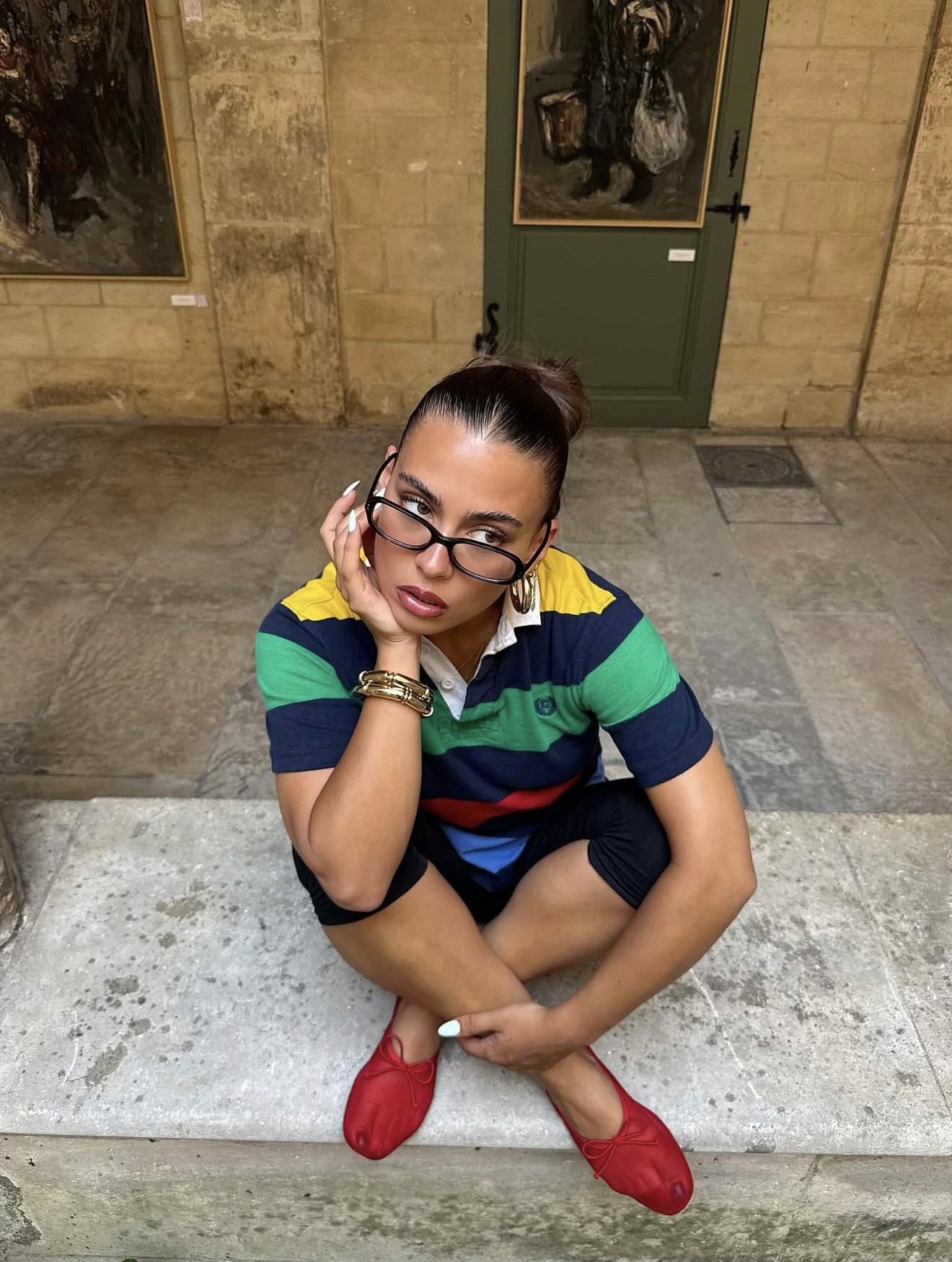 jade gattoni avec des lunettes assise sur un banc en pierre