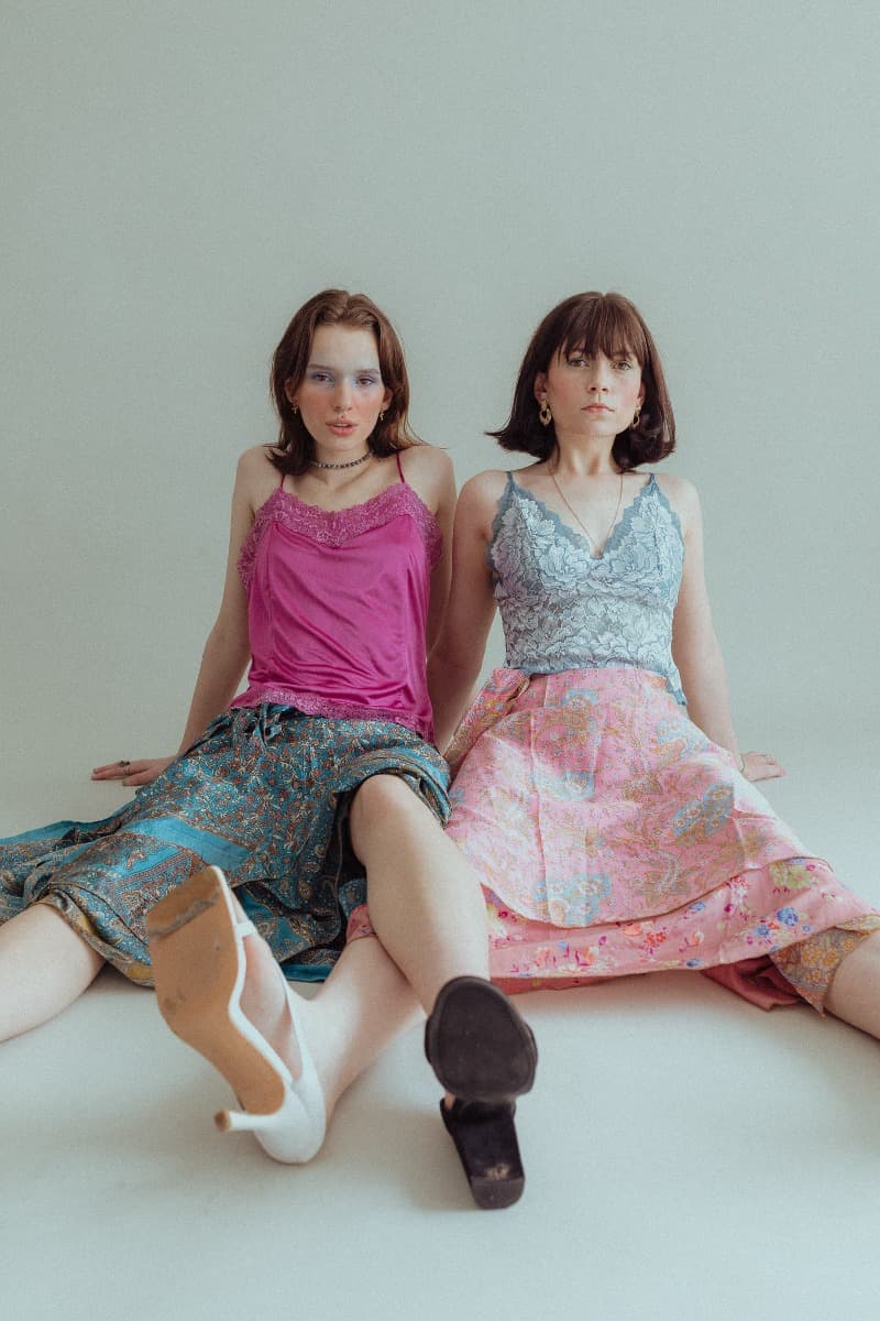 Two models sitting on the floor after a creative shoot at Revelator Studio in Shreveport, highlighting the ethereal and natural light.