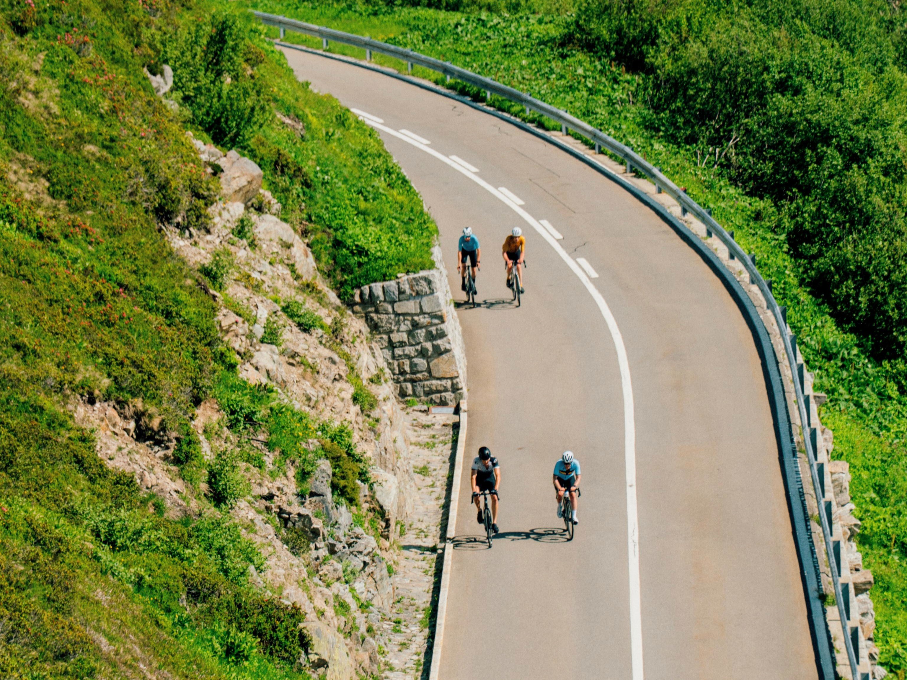 Group of cyclists descending quiet mountain road in the Swiss Alps