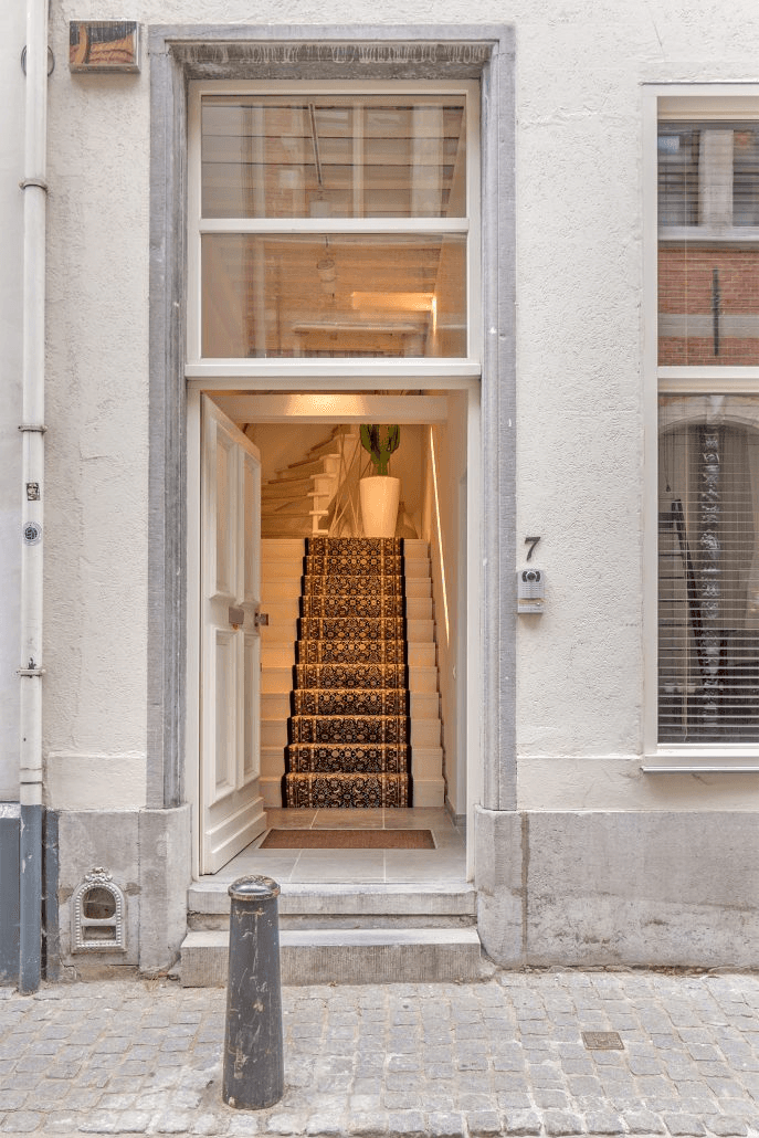 a bed with white sheets and pillows in a room