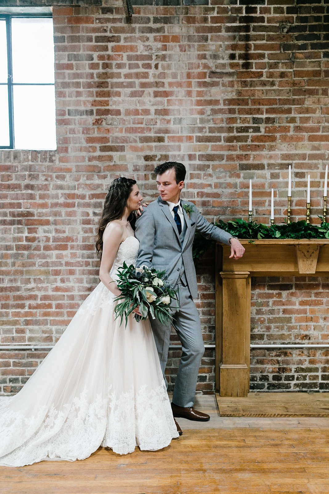 Rustic Des Moines wedding with bride in lace gown and groom in gray suit.
