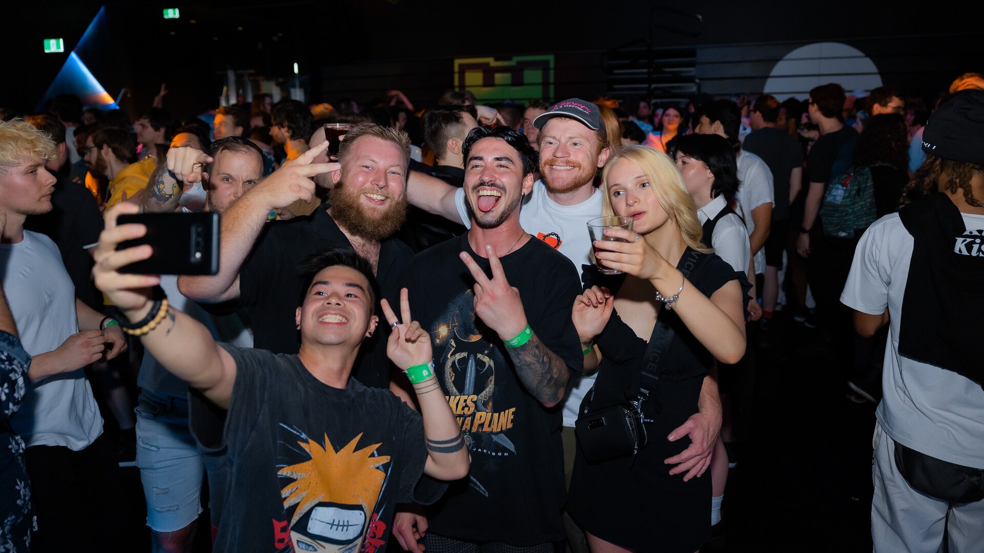 group of friends taking a selfie in the middle of a packed dancefloor