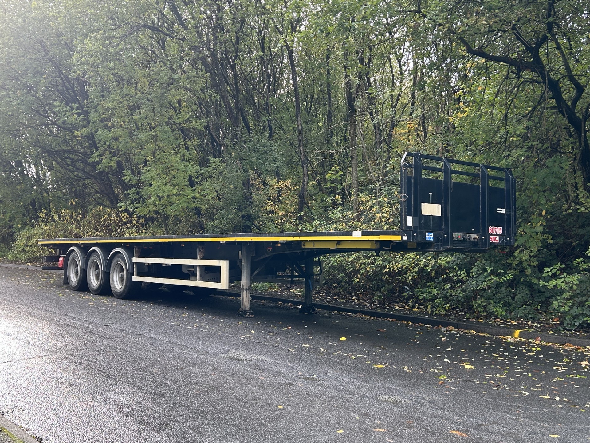 image of a flatbed trailer parked outside a warehouse waiting for use 