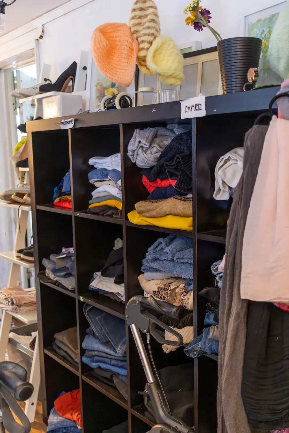 Sorterade kläder i hyllor tillgängliga för besökare.