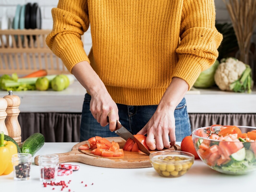 woman cooking a healthy meal after feeling energized by an Epsom salt bath for fat loss after working out