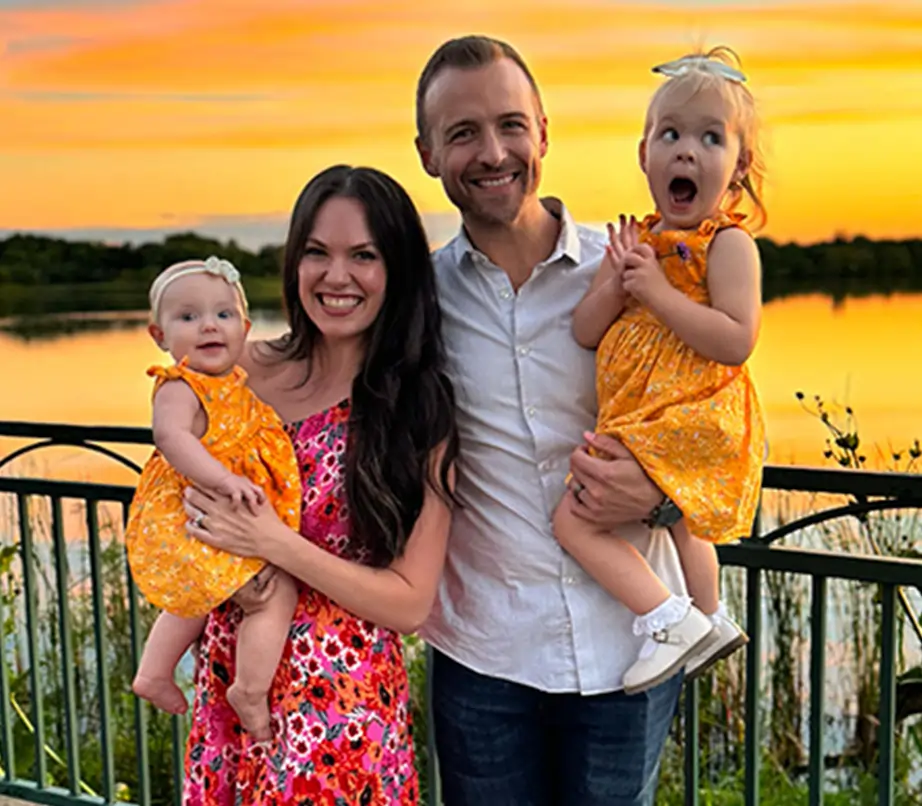 Family photo of the founders and their daughter with a sunset backdrop. 