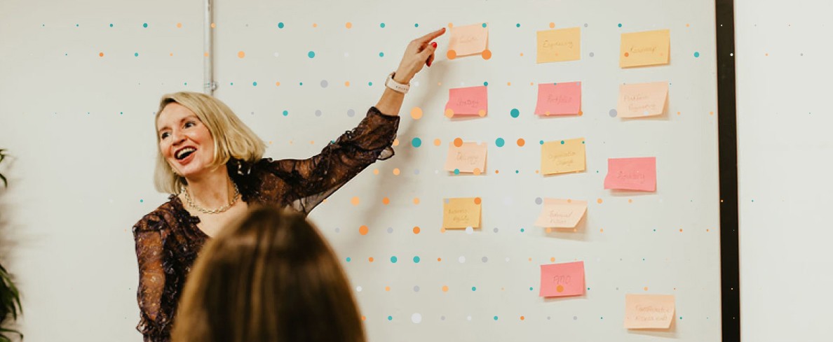 Lean Tree team member pointing at post it notes ranked on the wall