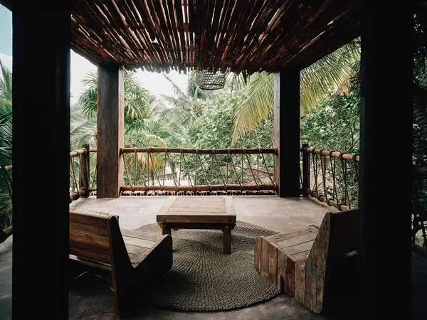 Arena Room balcony at Nômade Tulum featuring 2 chairs, table, and stunning jungle view.