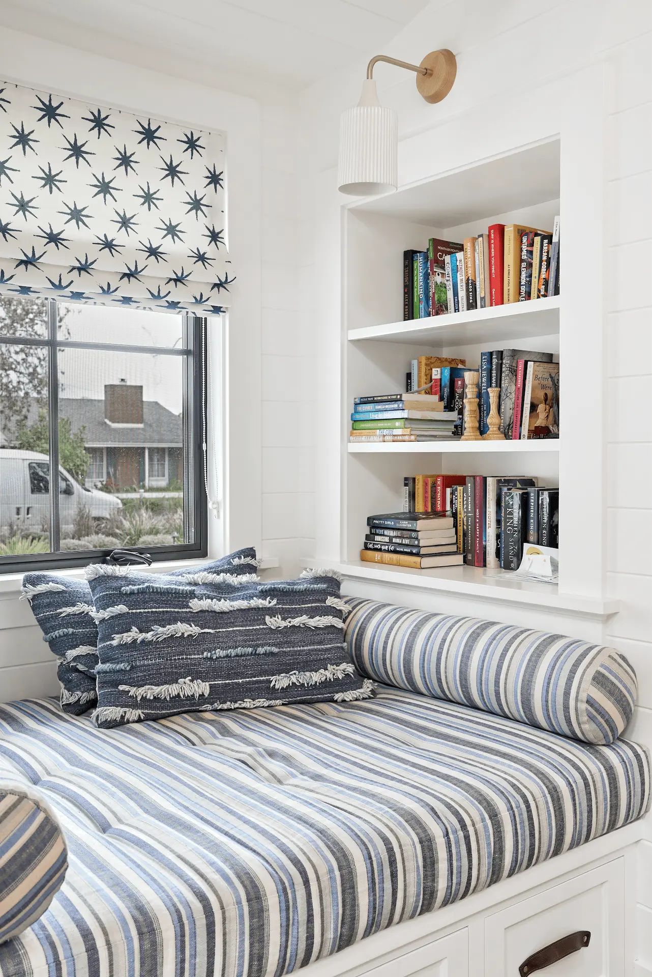 Close angle of cozy reading nook with cushioned bench and storage in North Tustin Remodel & Addition. Photo by Todd Huge.