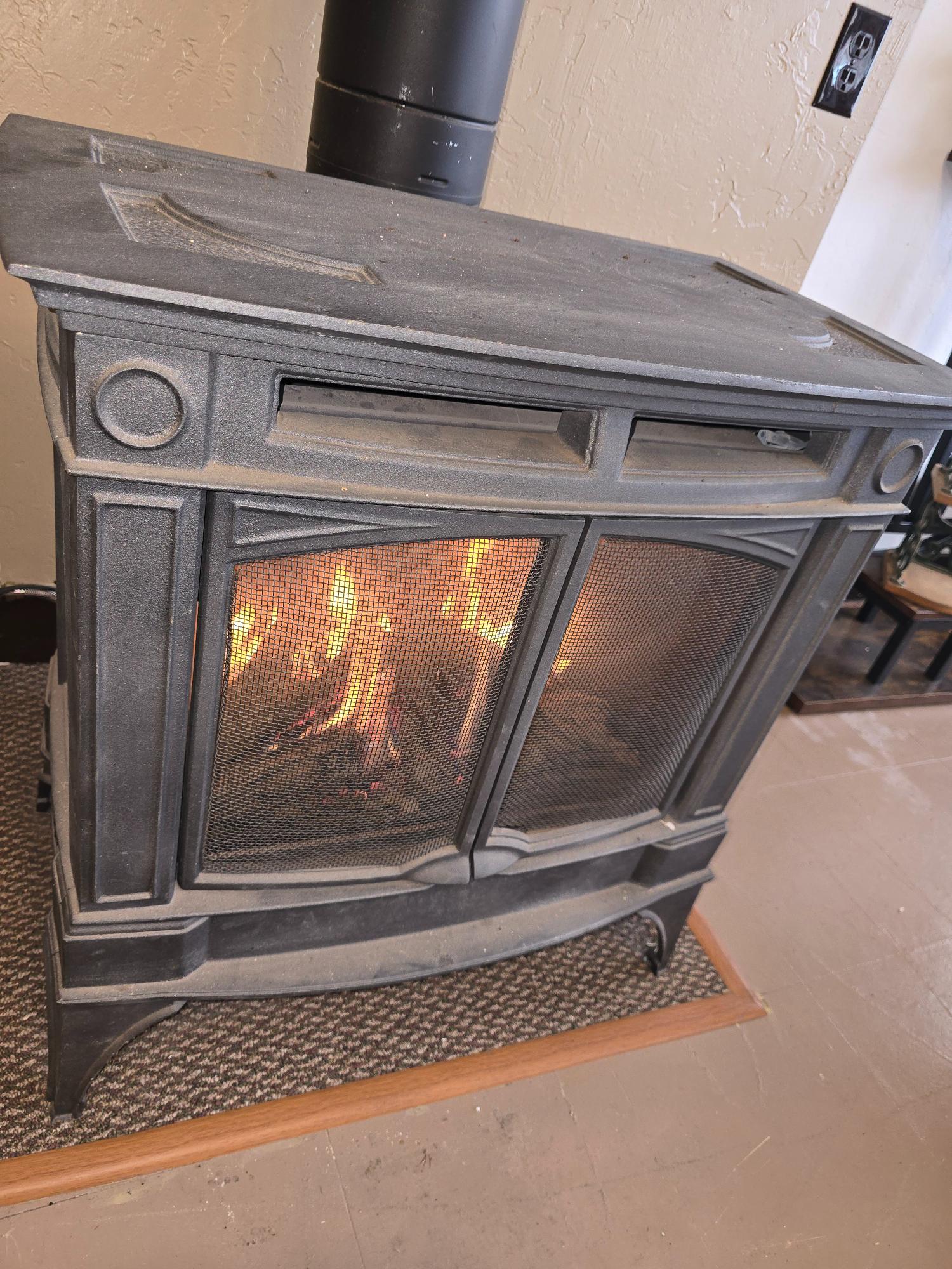 Black wood stove with a fire burning inside.