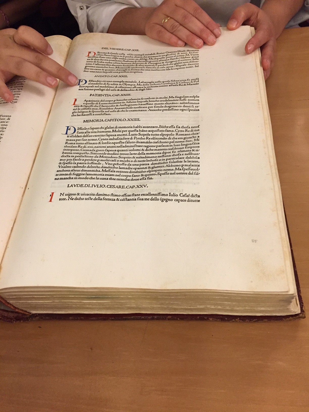 People checking text from an old book written in Latin.