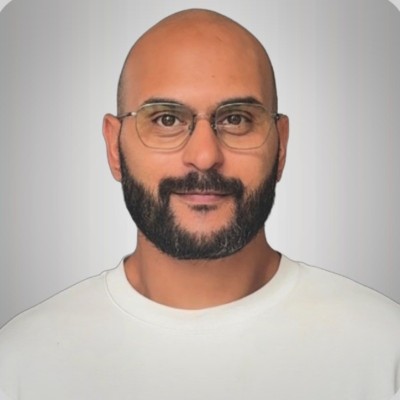 man wearing blue polo shirt with building background