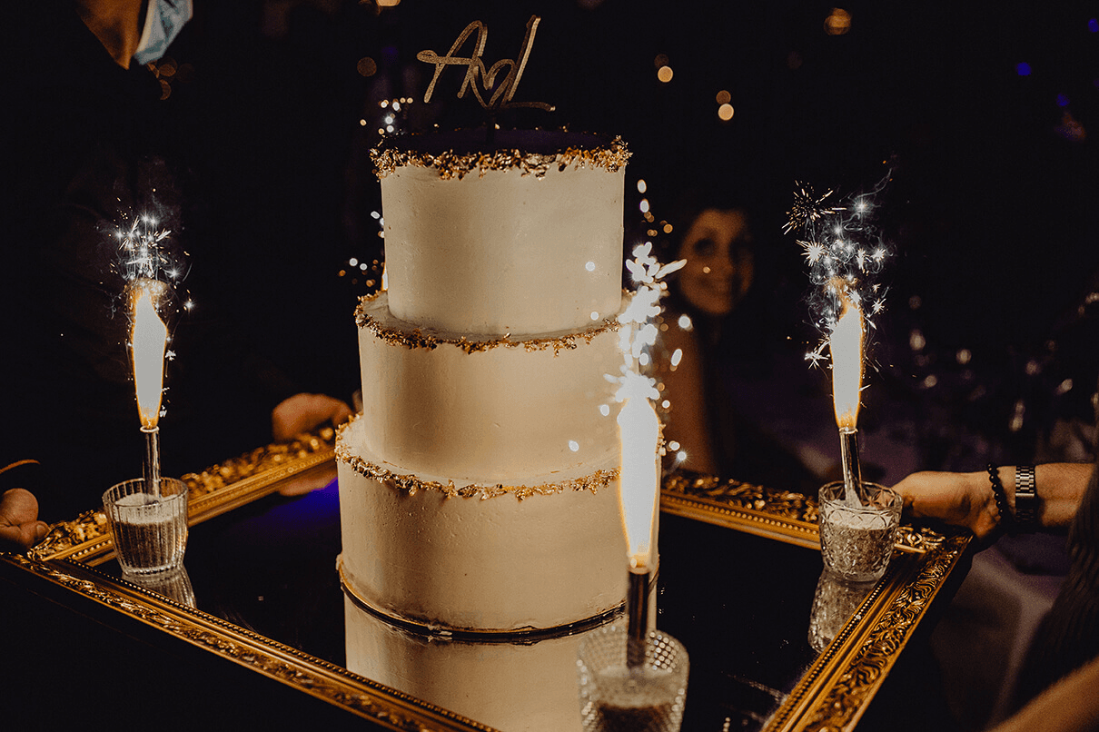 An elegant wedding ceremony setup features a domed gazebo adorned with peach and pink floral arrangements and lush greenery. White chairs line the aisle.