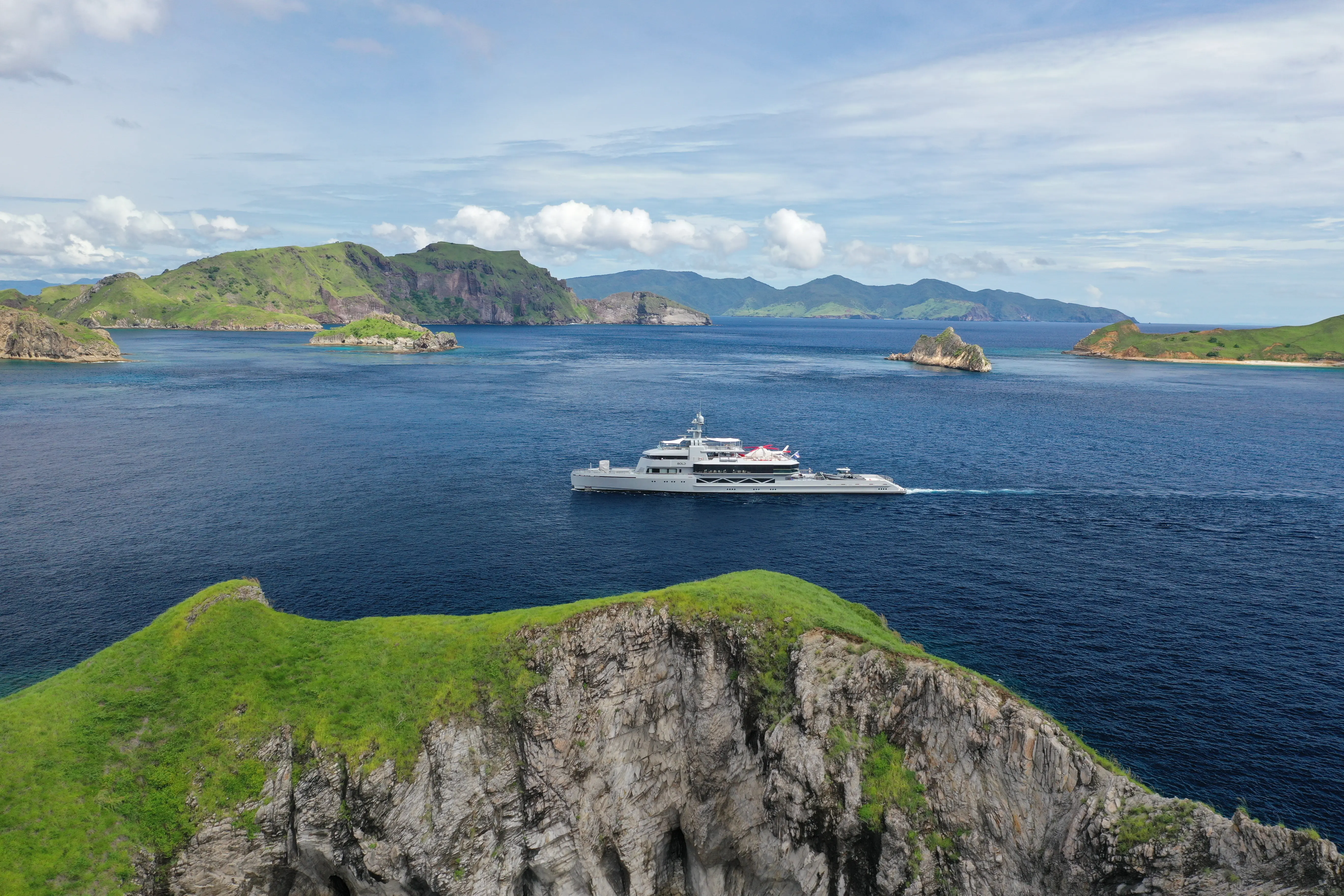 Indoor stone pool overlooking mountains with pink flowers.